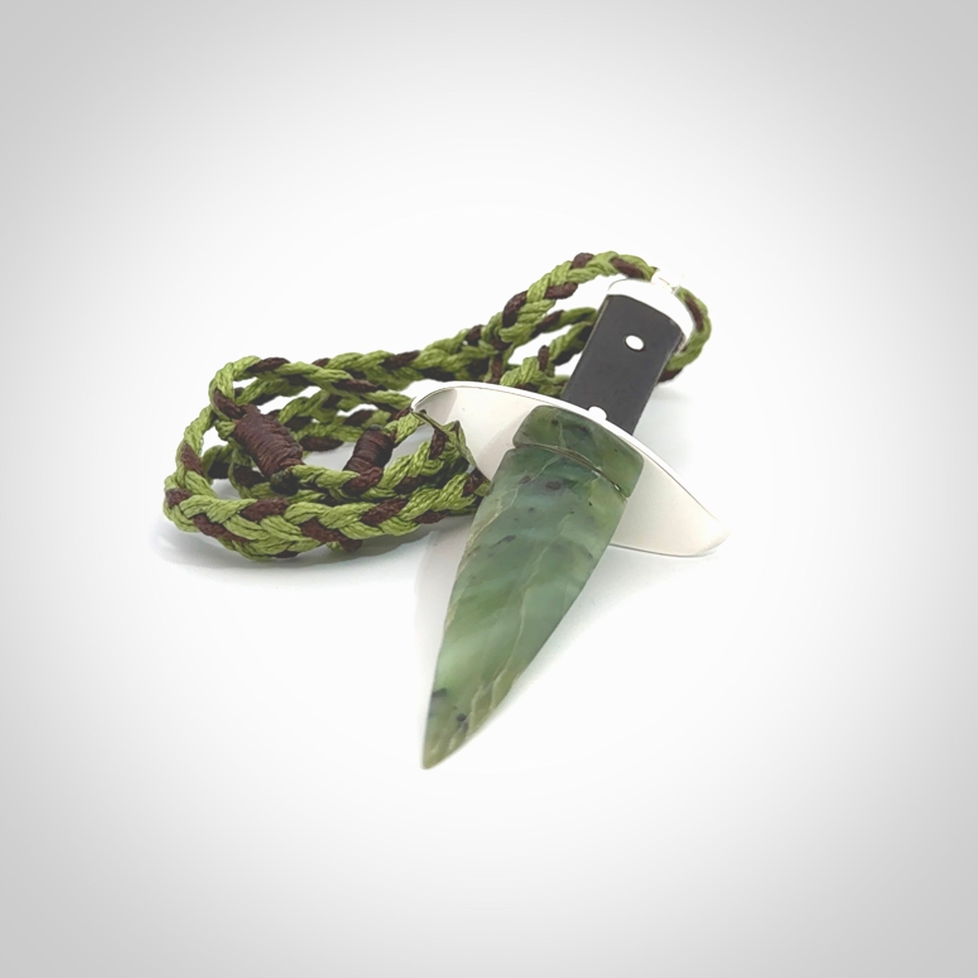 A striking hand carved knife pendant. These are carved with a green jade head and a hardwood handle. The cords are hand plaited in our waxed polyester which is robust, strong and durable. We ship these worldwide with express courier.