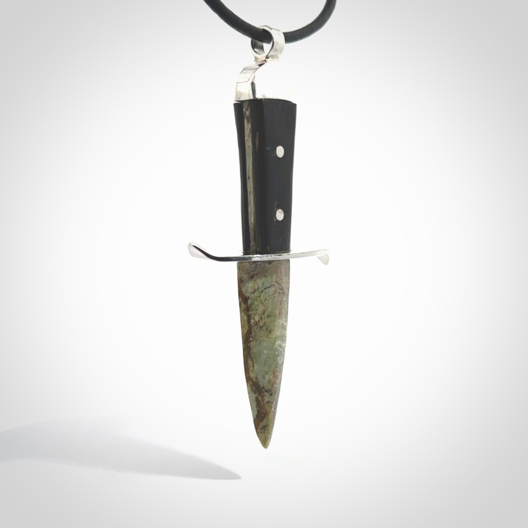 A striking hand carved knife pendant. These are carved with a green jade head and a hardwood handle. The necklace is made of leather and has a clasp fixture. We ship these worldwide with express courier.