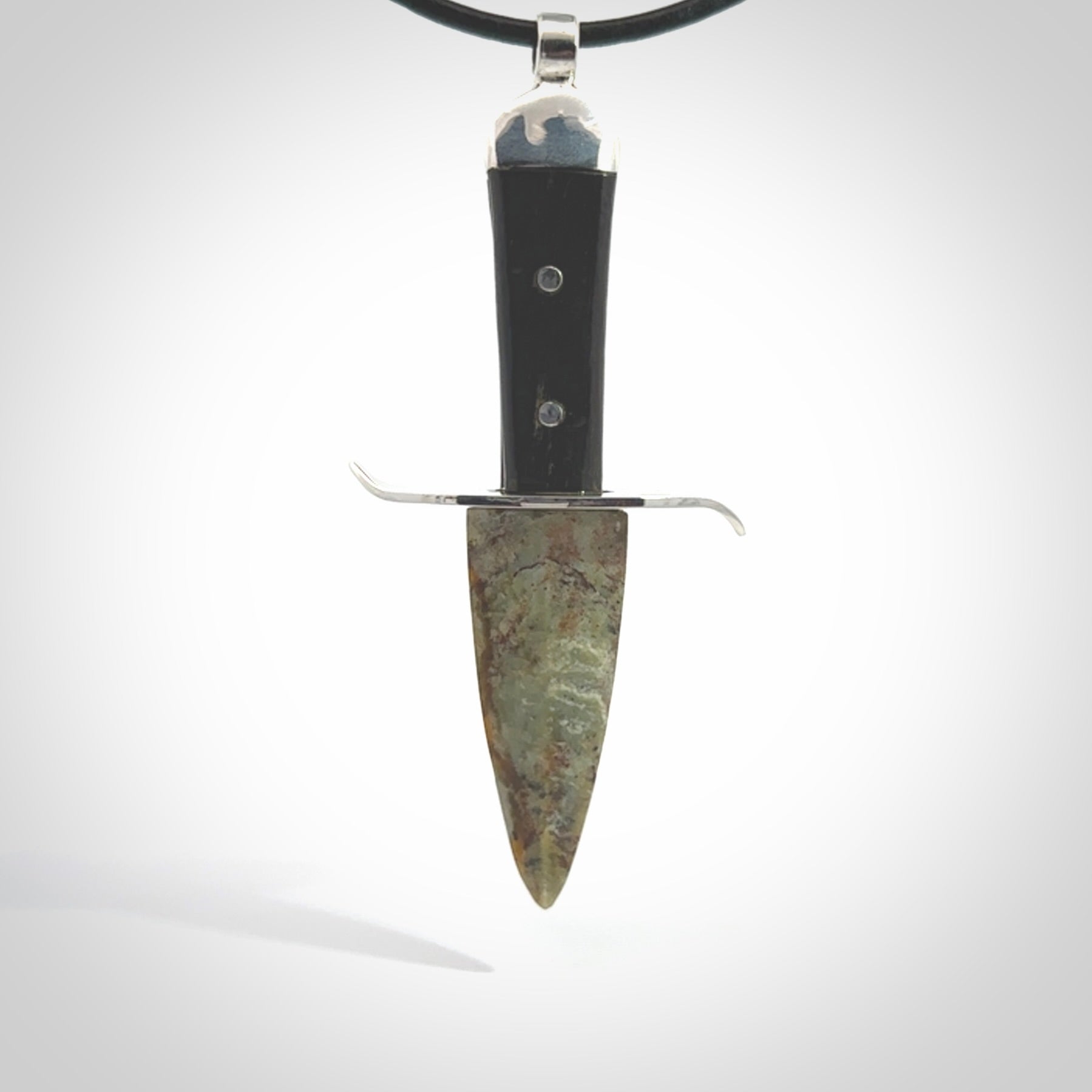 A striking hand carved knife pendant. These are carved with a green jade head and a hardwood handle. The necklace is made of leather and has a clasp fixture. We ship these worldwide with express courier.