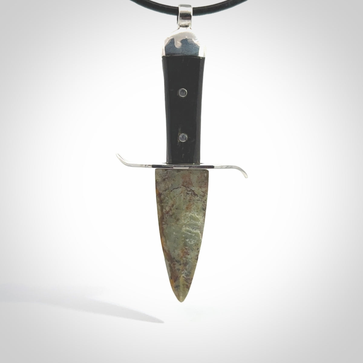 A striking hand carved knife pendant. These are carved with a green jade head and a hardwood handle. The necklace is made of leather and has a clasp fixture. We ship these worldwide with express courier.