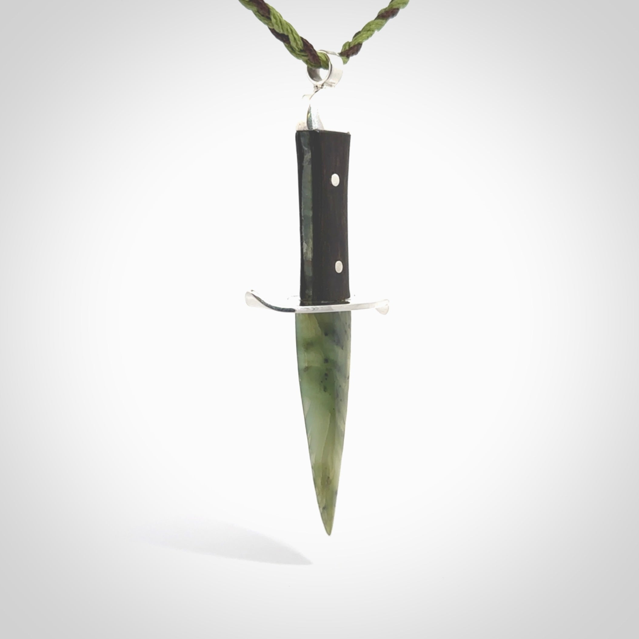 A striking hand carved knife pendant. These are carved with a green jade head and a hardwood handle. The cords are hand plaited in our waxed polyester which is robust, strong and durable. We ship these worldwide with express courier.