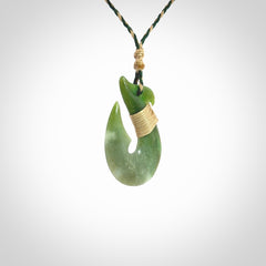 Hand carved New Zealand Jade Hook Pendant. Maori matau necklace hand carved. Jade Hook pendant provided with adjustable cord and packaged in a woven kete pouch. Delivered with Express Courier.