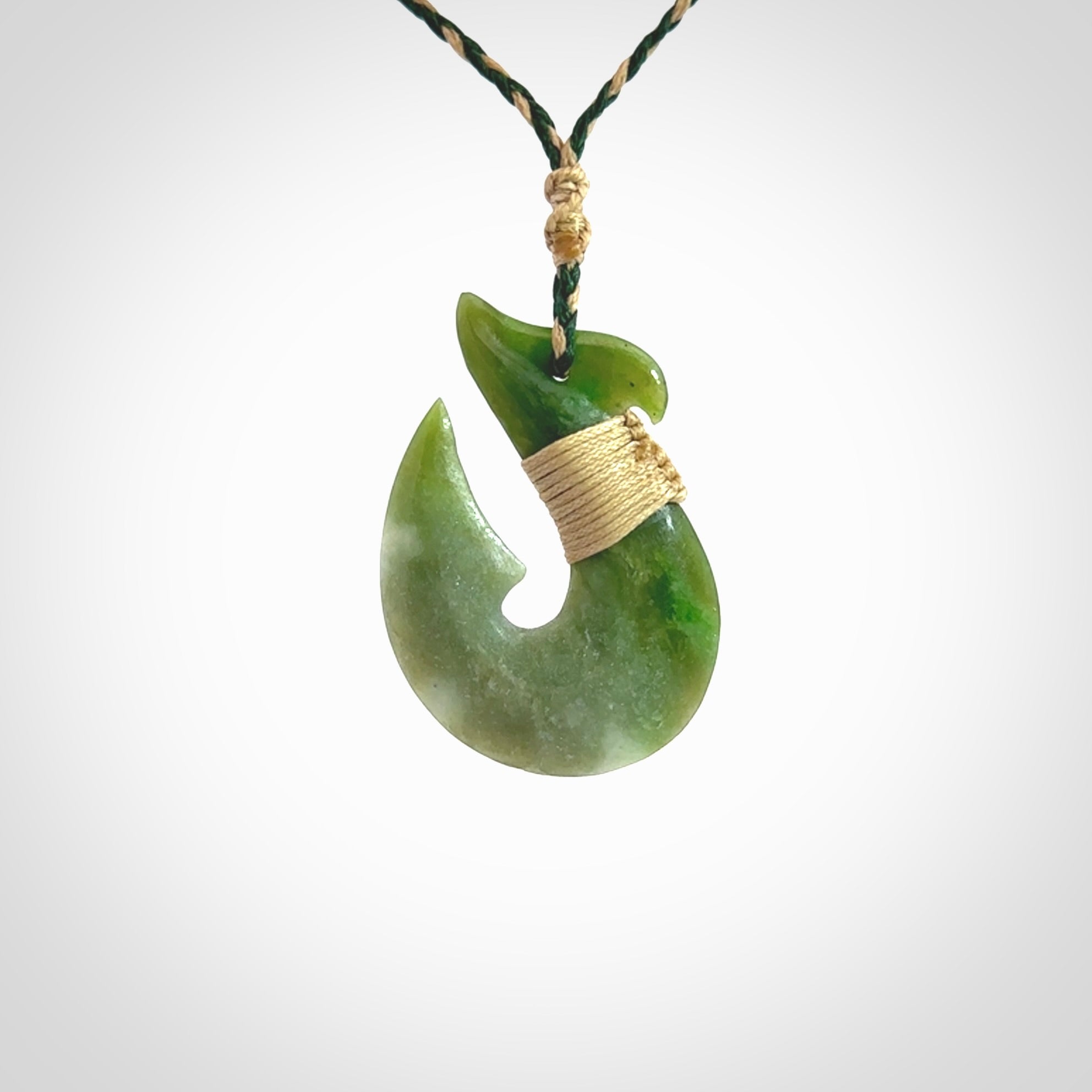 Hand carved New Zealand Jade Hook Pendant. Maori matau necklace hand carved. Jade Hook pendant provided with adjustable cord and packaged in a woven kete pouch. Delivered with Express Courier.