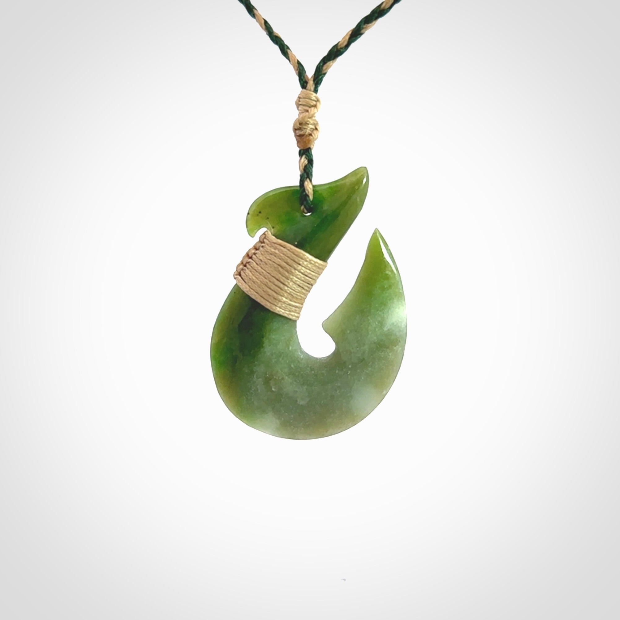 Hand carved New Zealand Jade Hook Pendant. Maori matau necklace hand carved. Jade Hook pendant provided with adjustable cord and packaged in a woven kete pouch. Delivered with Express Courier.