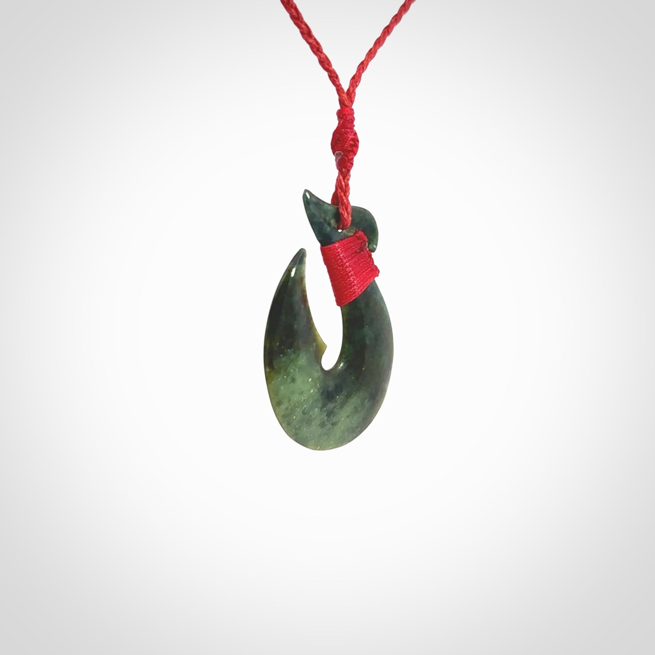 Hand carved New Zealand Jade Hook Pendant. Maori matau necklace hand carved. Jade Hook pendant provided with adjustable cord and packaged in a woven kete pouch. Delivered with Express Courier.