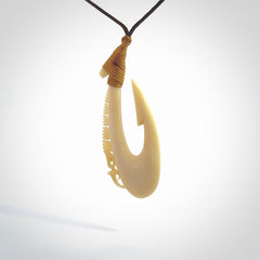 Natural cow bone hook with Manaia pendant. Hand carved by Yuri Terenyi in New Zealand. Maori design pendant for sale online. Natural bone manaia, hook necklace with adjustable cord. Free delivery worldwide.