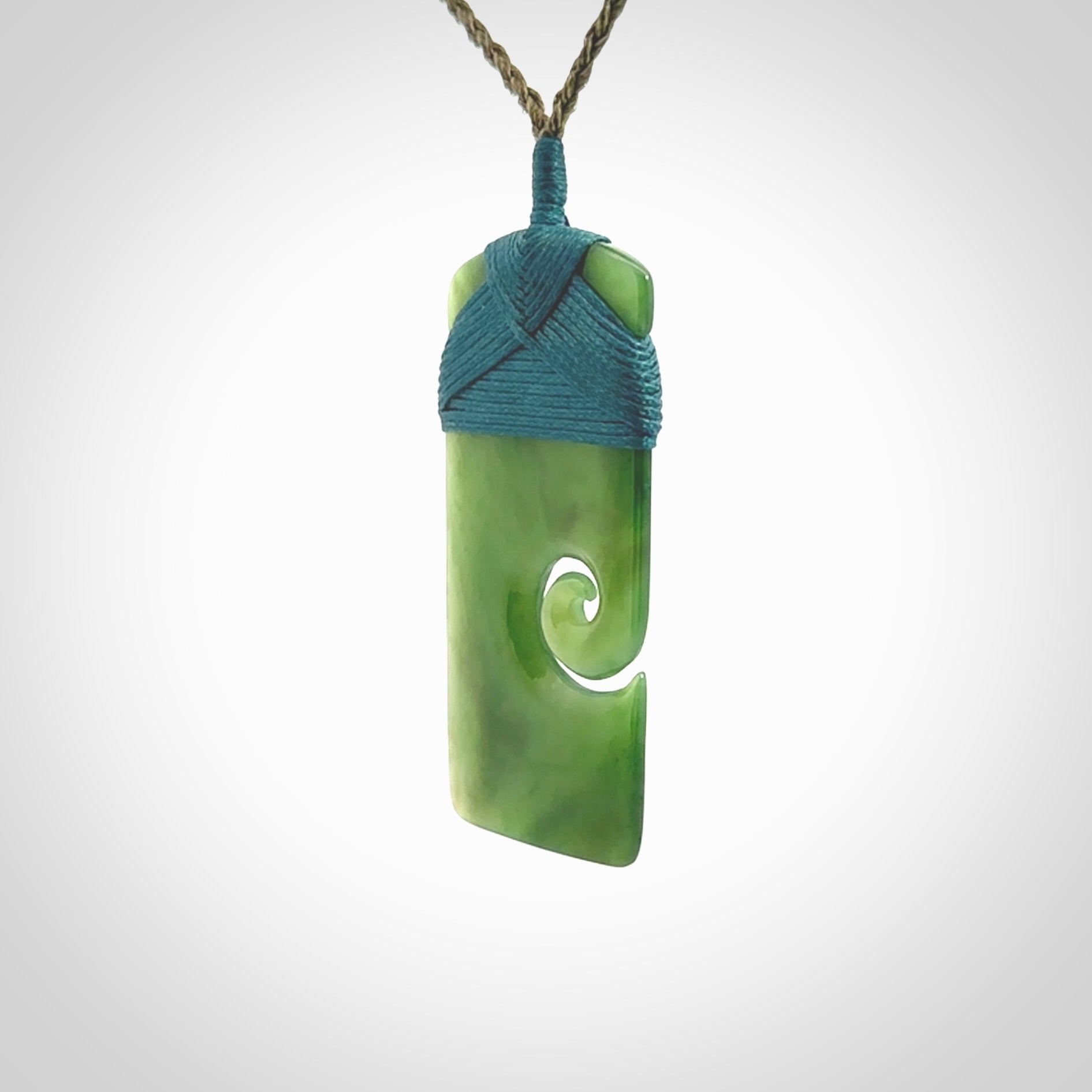 New Zealand jade toki koru pendant. Hand carved in New Zealand. Hand made New Zealand Jade jewellery. Provided with an adjustable cord and packaged in a woven kete pouch.