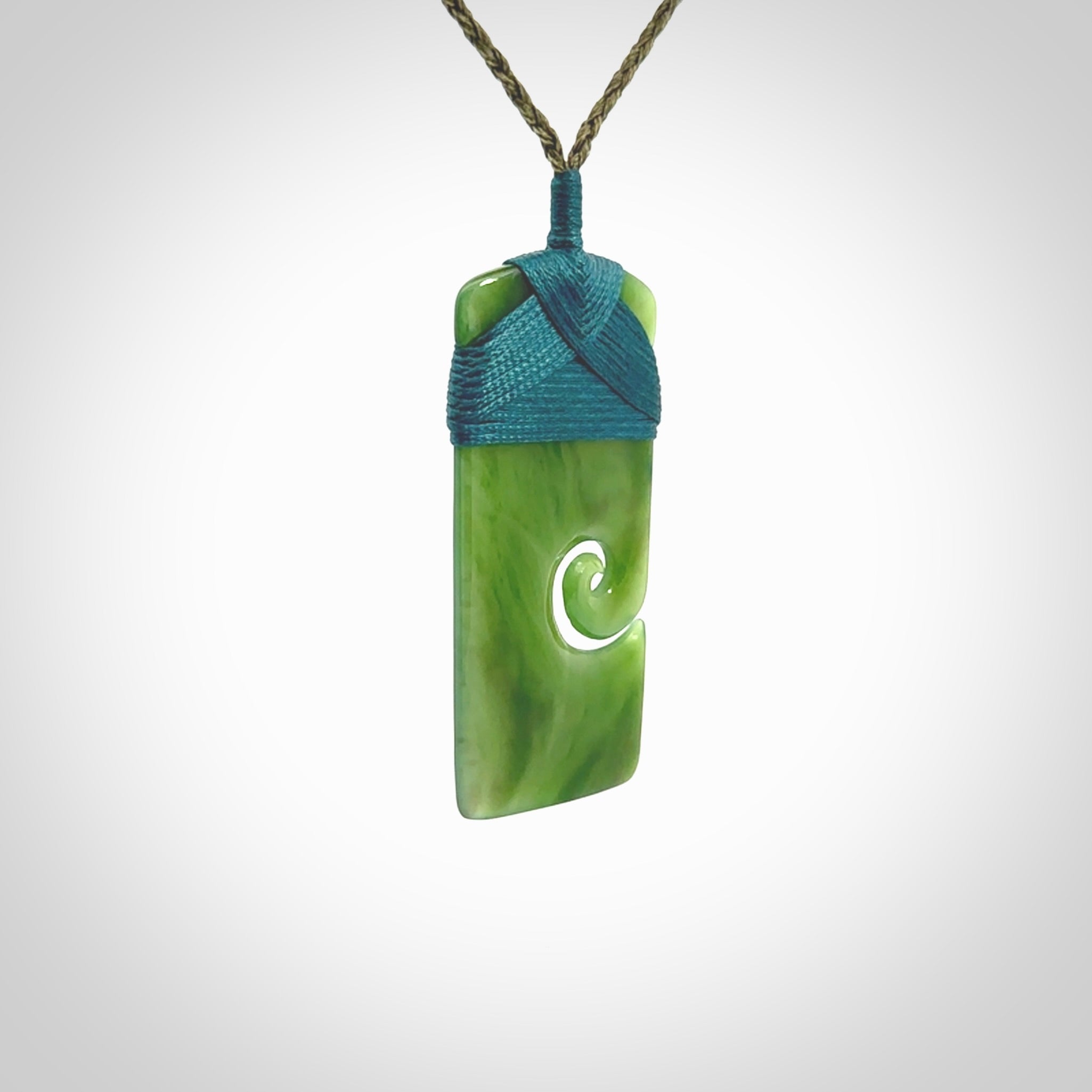 New Zealand jade toki koru pendant. Hand carved in New Zealand. Hand made New Zealand Jade jewellery. Provided with an adjustable cord and packaged in a woven kete pouch.