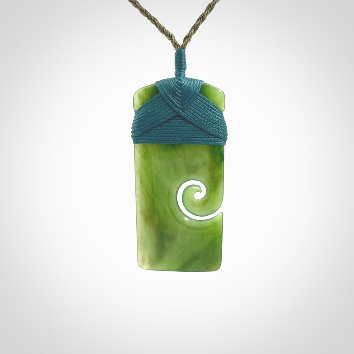 New Zealand jade toki koru pendant. Hand carved in New Zealand. Hand made New Zealand Jade jewellery. Provided with an adjustable cord and packaged in a woven kete pouch.