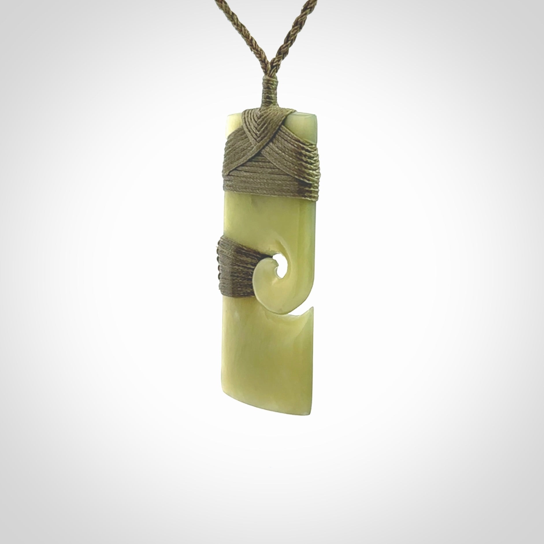 New Zealand jade toki koru pendant. Hand carved in New Zealand. Hand made New Zealand Jade jewellery. Provided with an adjustable cord and packaged in a woven kete pouch.