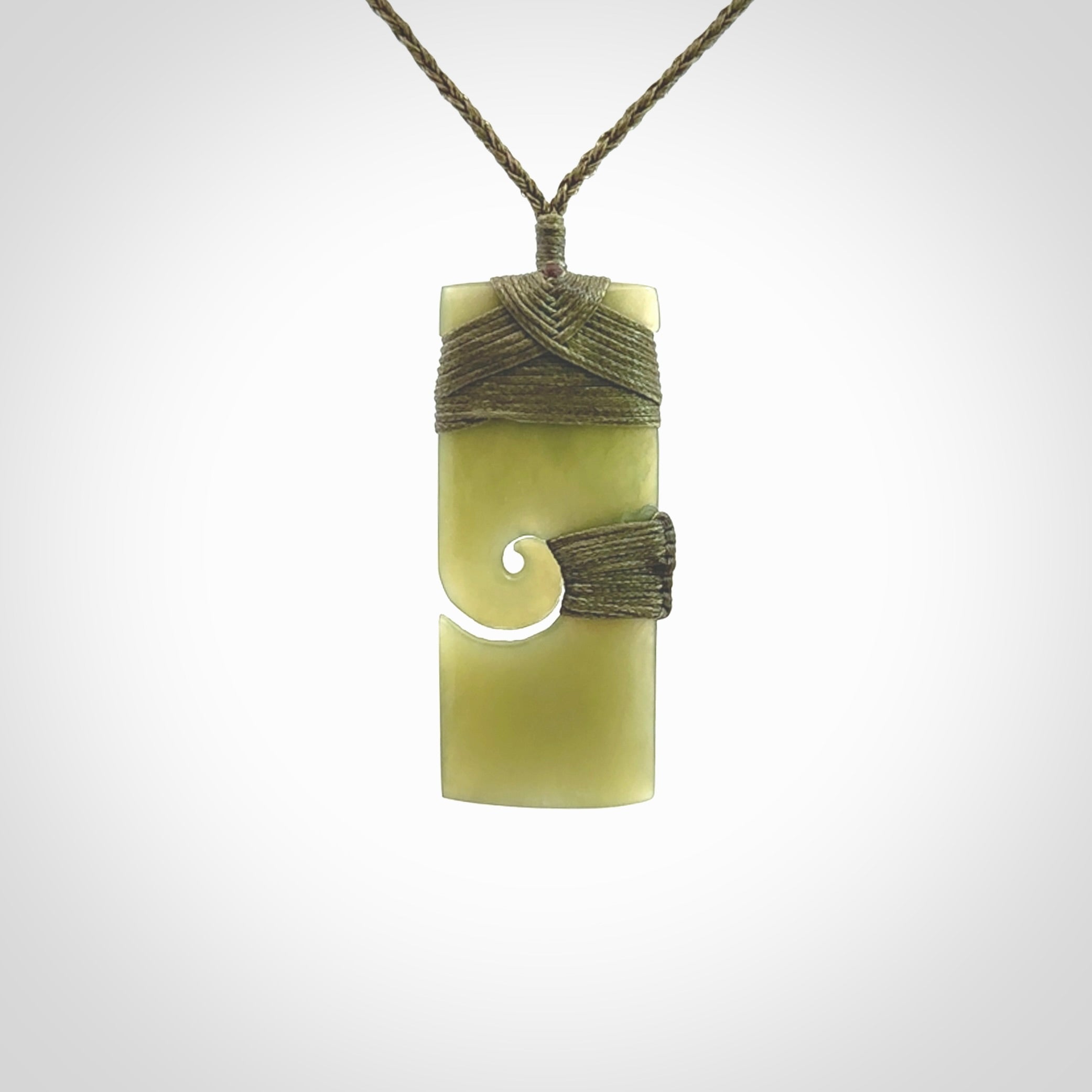 New Zealand jade toki koru pendant. Hand carved in New Zealand. Hand made New Zealand Jade jewellery. Provided with an adjustable cord and packaged in a woven kete pouch.