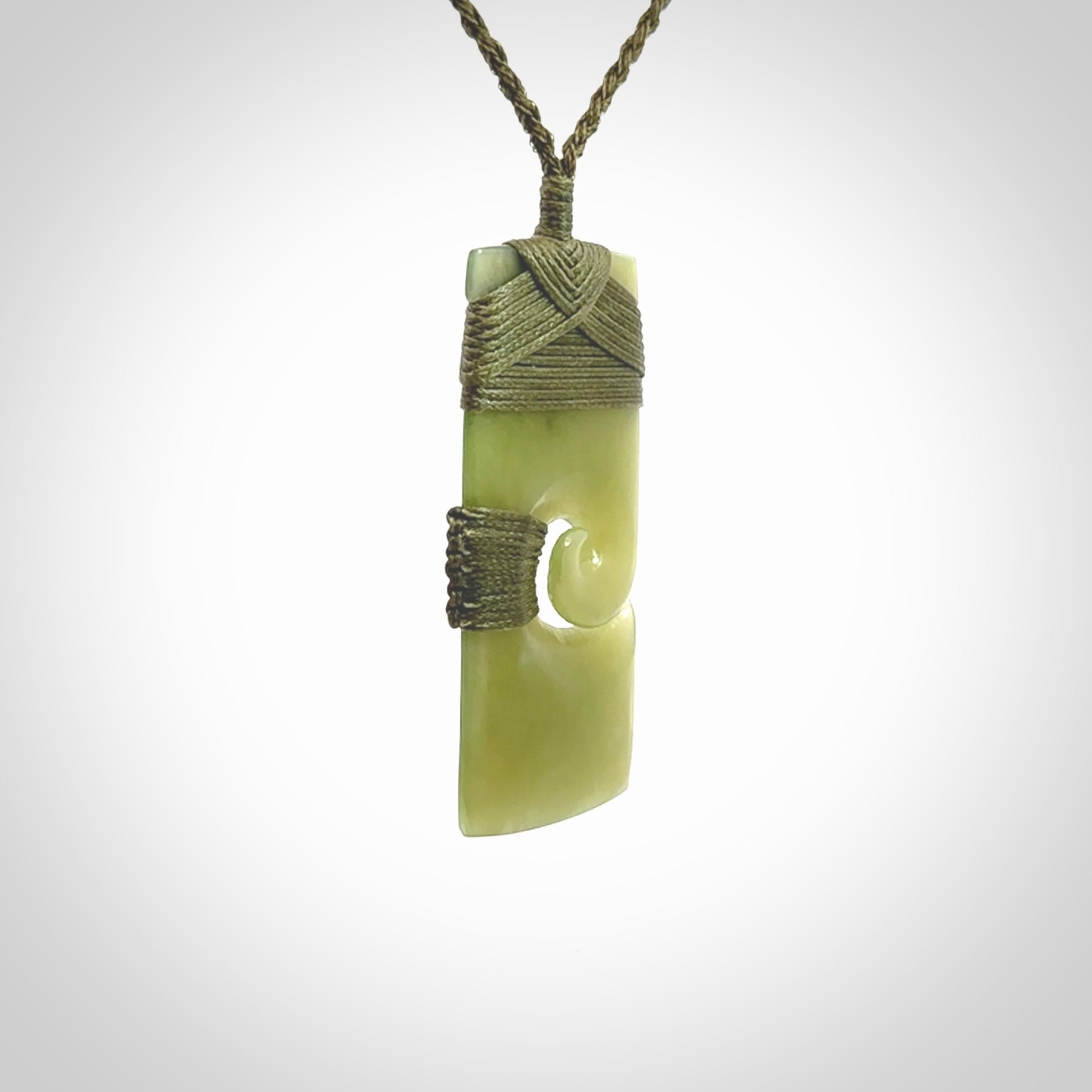 New Zealand jade toki koru pendant. Hand carved in New Zealand. Hand made New Zealand Jade jewellery. Provided with an adjustable cord and packaged in a woven kete pouch.