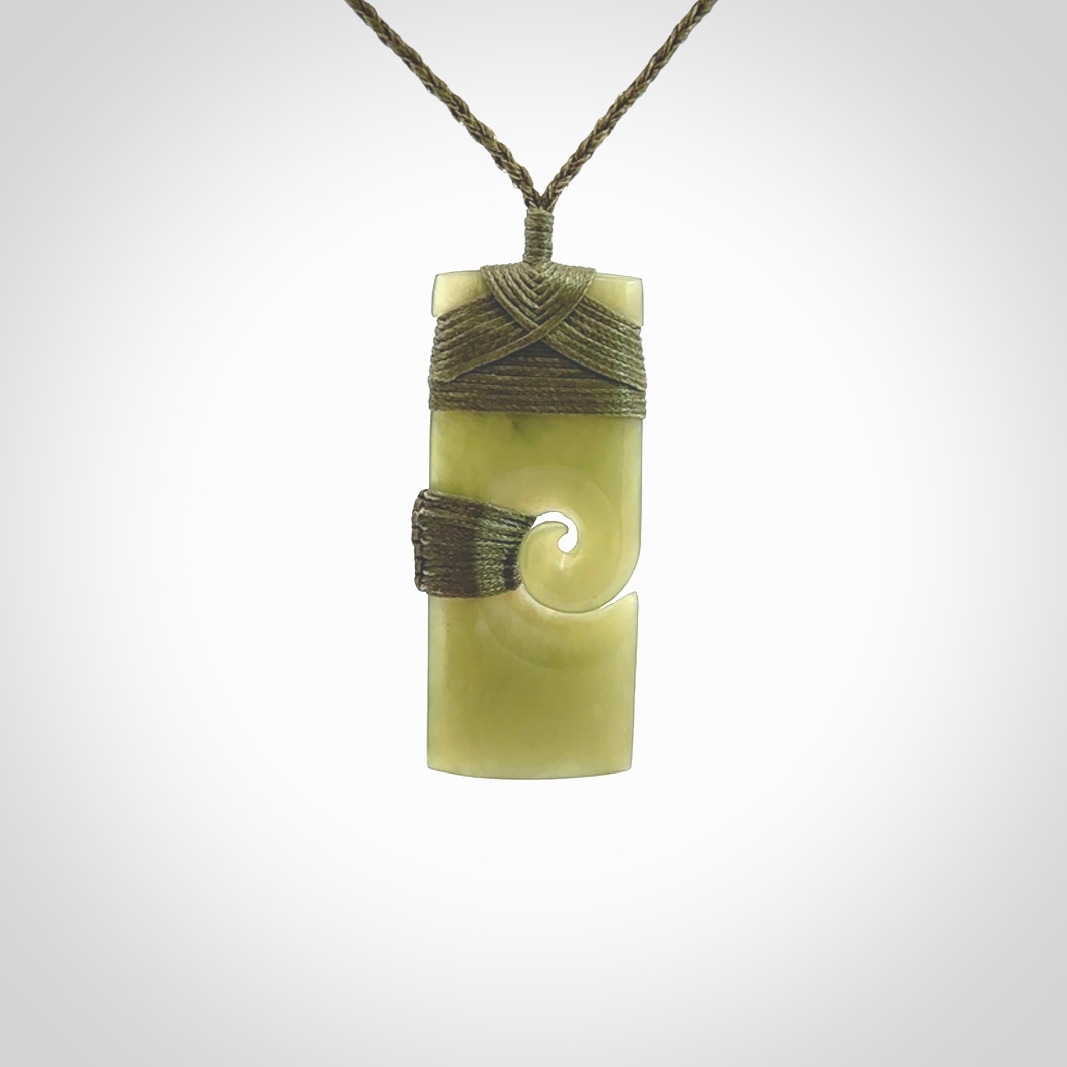 New Zealand jade toki koru pendant. Hand carved in New Zealand. Hand made New Zealand Jade jewellery. Provided with an adjustable cord and packaged in a woven kete pouch.