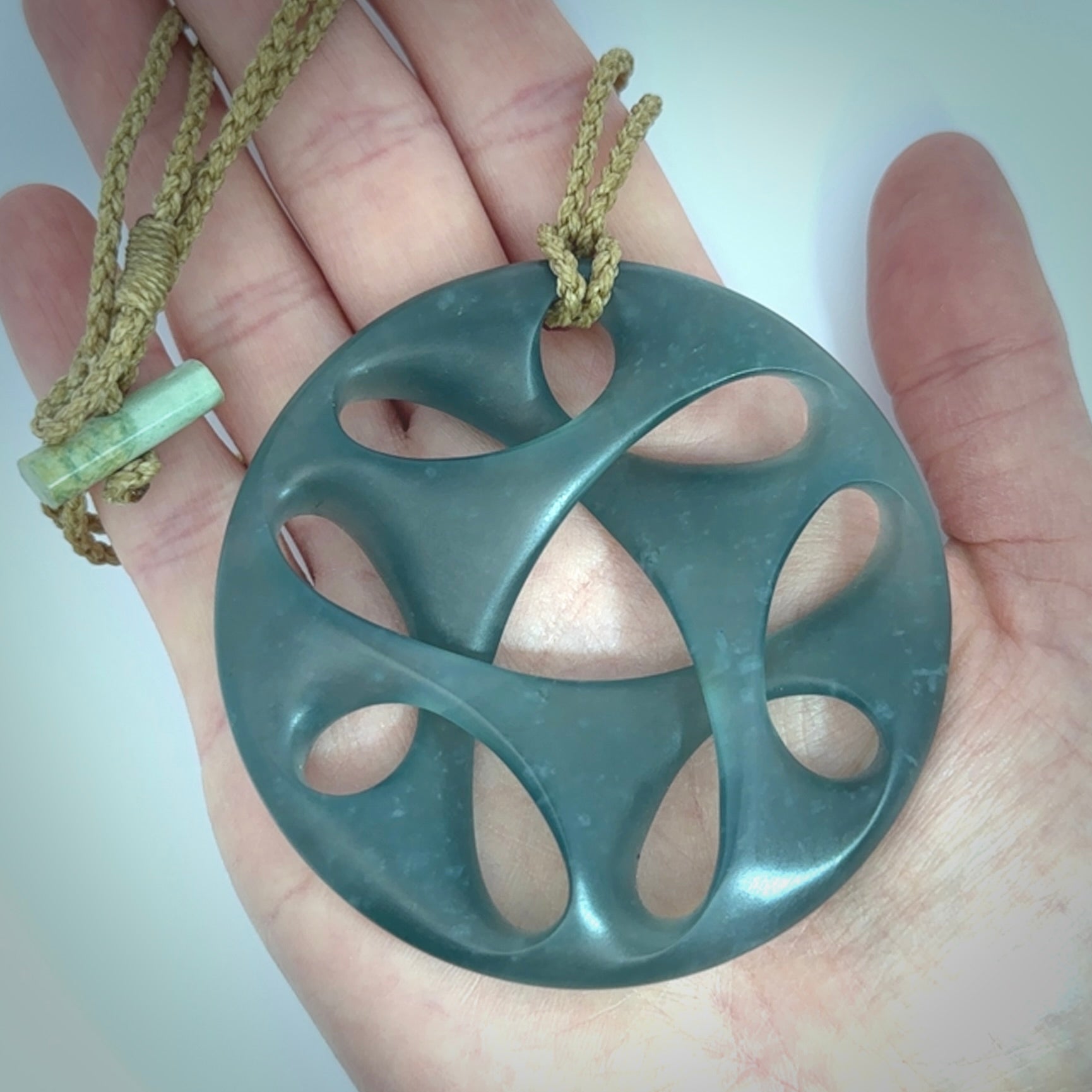 This large piece is a hand carved complex twist pendant. Kerry carved this from Guatemalan Jade. It is a gorgeous blue colour and is an artistic piece of jewellery. Hand made by Kerry Thompson and delivered to you in a kete pouch.