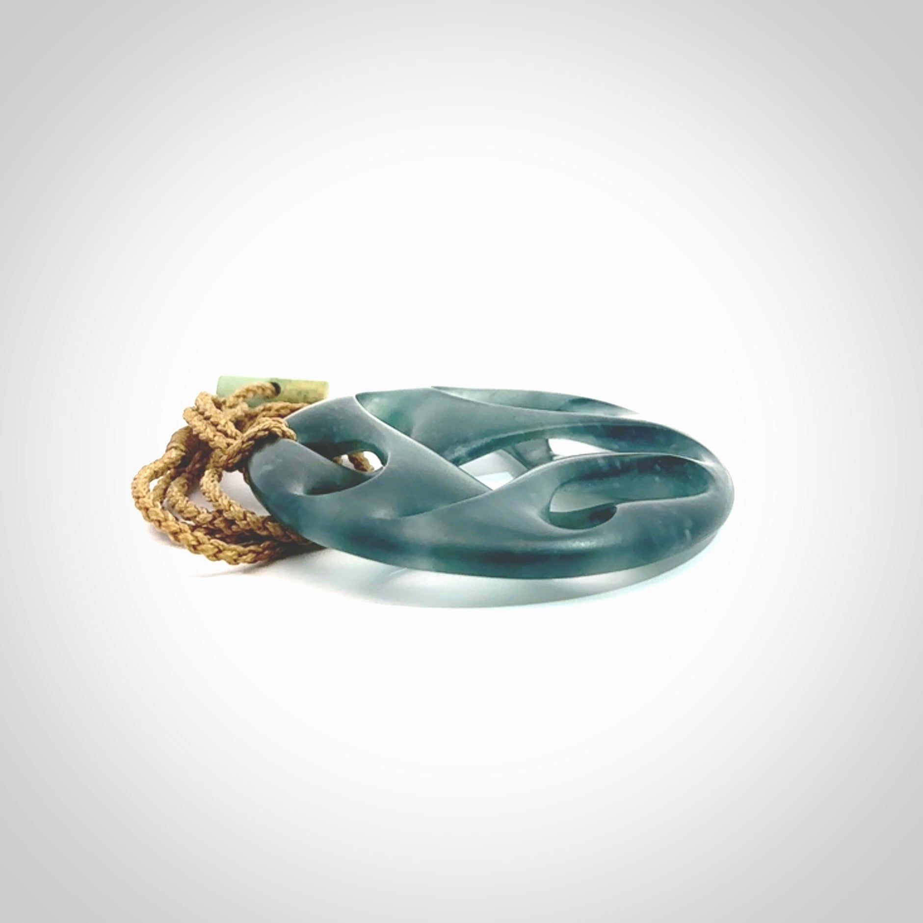 This large piece is a hand carved complex twist pendant. Kerry carved this from Guatemalan Jade. It is a gorgeous blue colour and is an artistic piece of jewellery. Hand made by Kerry Thompson and delivered to you in a kete pouch.