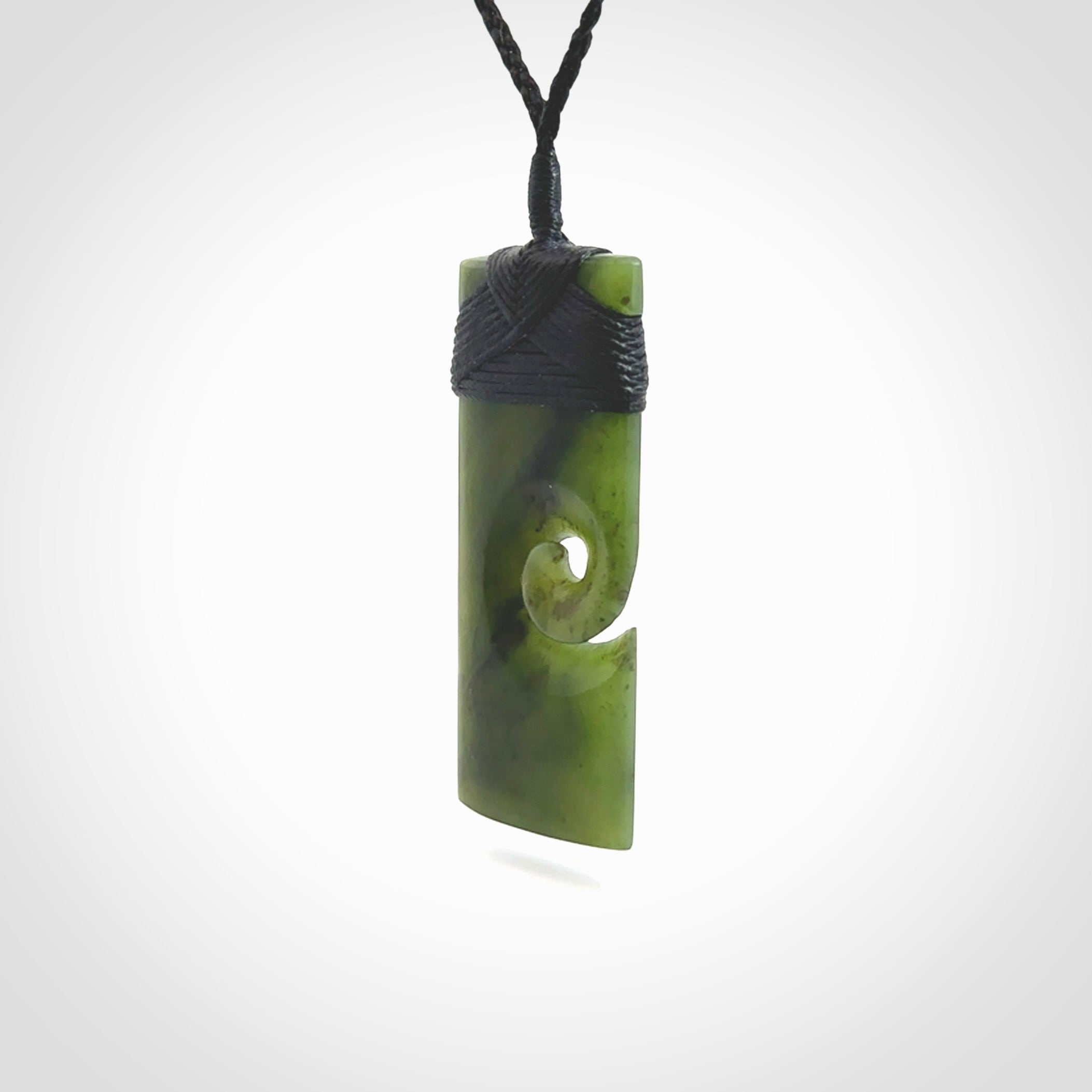 New Zealand jade toki koru pendant. Hand carved in New Zealand. Hand made New Zealand Jade jewellery. Provided with an adjustable cord and packaged in a woven kete pouch.