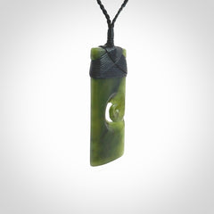 New Zealand jade toki koru pendant. Hand carved in New Zealand. Hand made New Zealand Jade jewellery. Provided with an adjustable cord and packaged in a woven kete pouch.