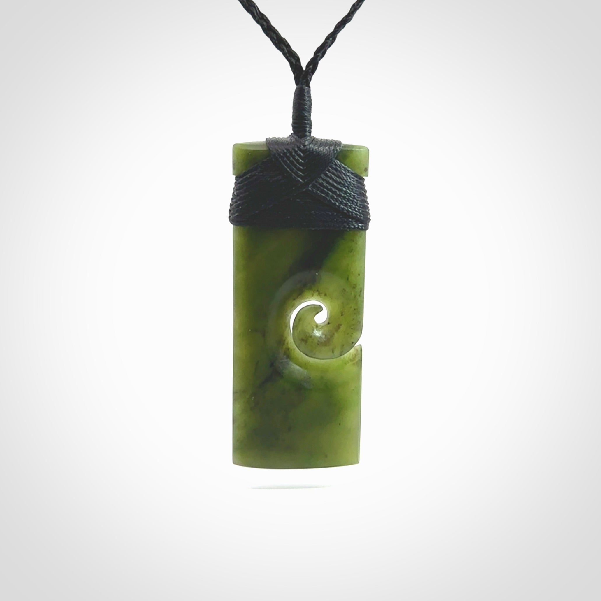 New Zealand jade toki koru pendant. Hand carved in New Zealand. Hand made New Zealand Jade jewellery. Provided with an adjustable cord and packaged in a woven kete pouch.