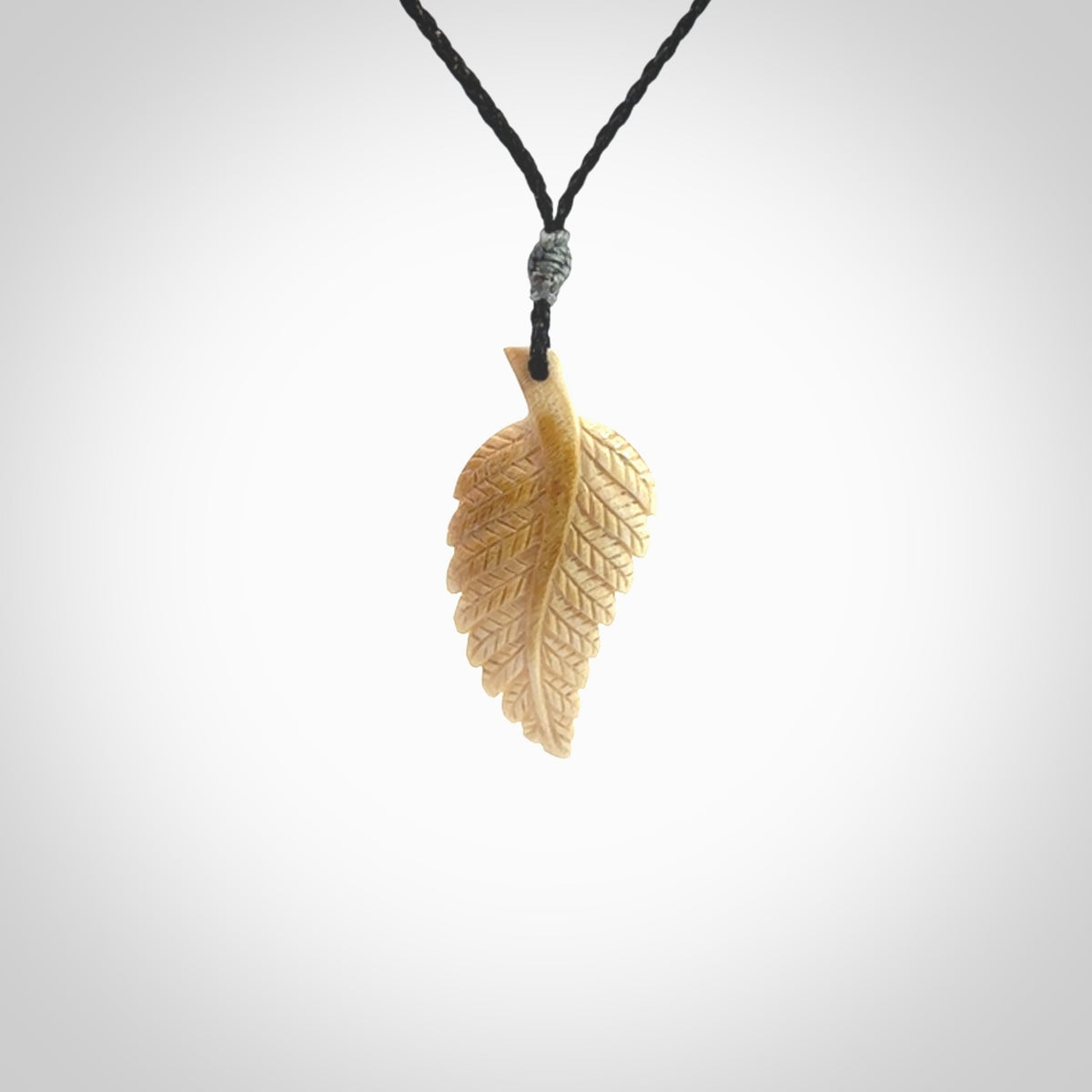 Hand carved woolly mammoth tusk fern pendant. Made in New Zealand. Unique hand made gifts from NZ Pacific. Hand carved fern necklace from ancient woolly mammoth tusk.