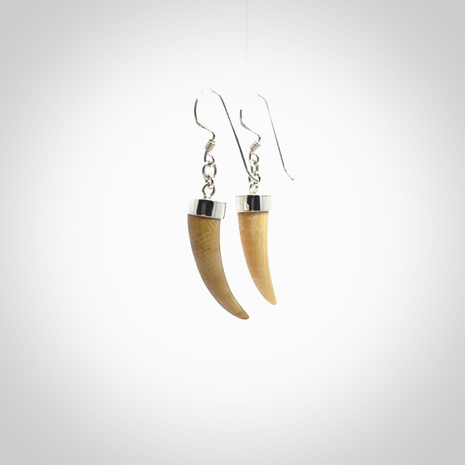 Hand made mammoth tusk drop earrings. Made by NZ Pacific - handmade jewellery for sale online. Woolly Mammoth Tusk fang style earrings, packaged in a woven kete pouch.