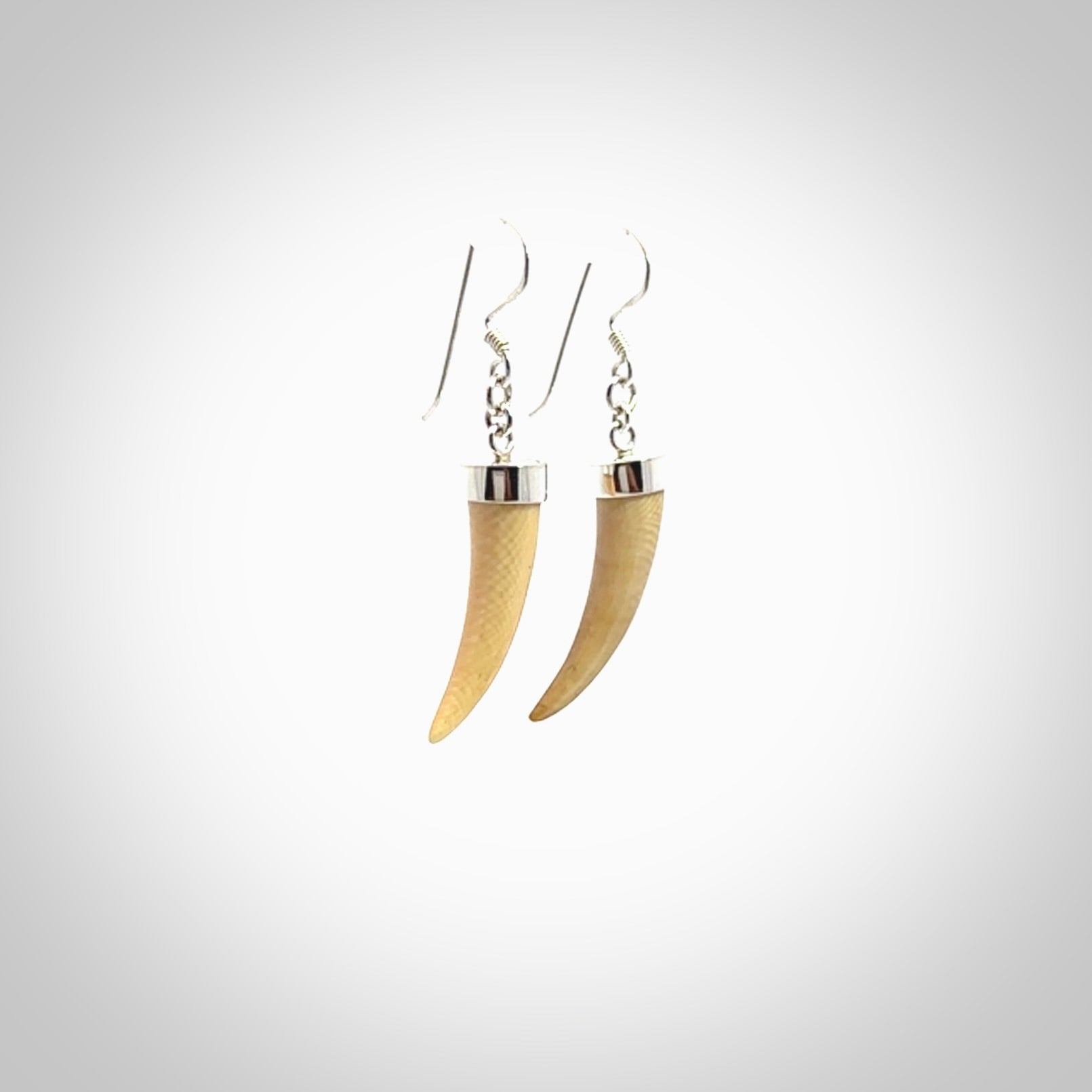 Hand made mammoth tusk drop earrings. Made by NZ Pacific - handmade jewellery for sale online. Woolly Mammoth Tusk fang style earrings, packaged in a woven kete pouch.