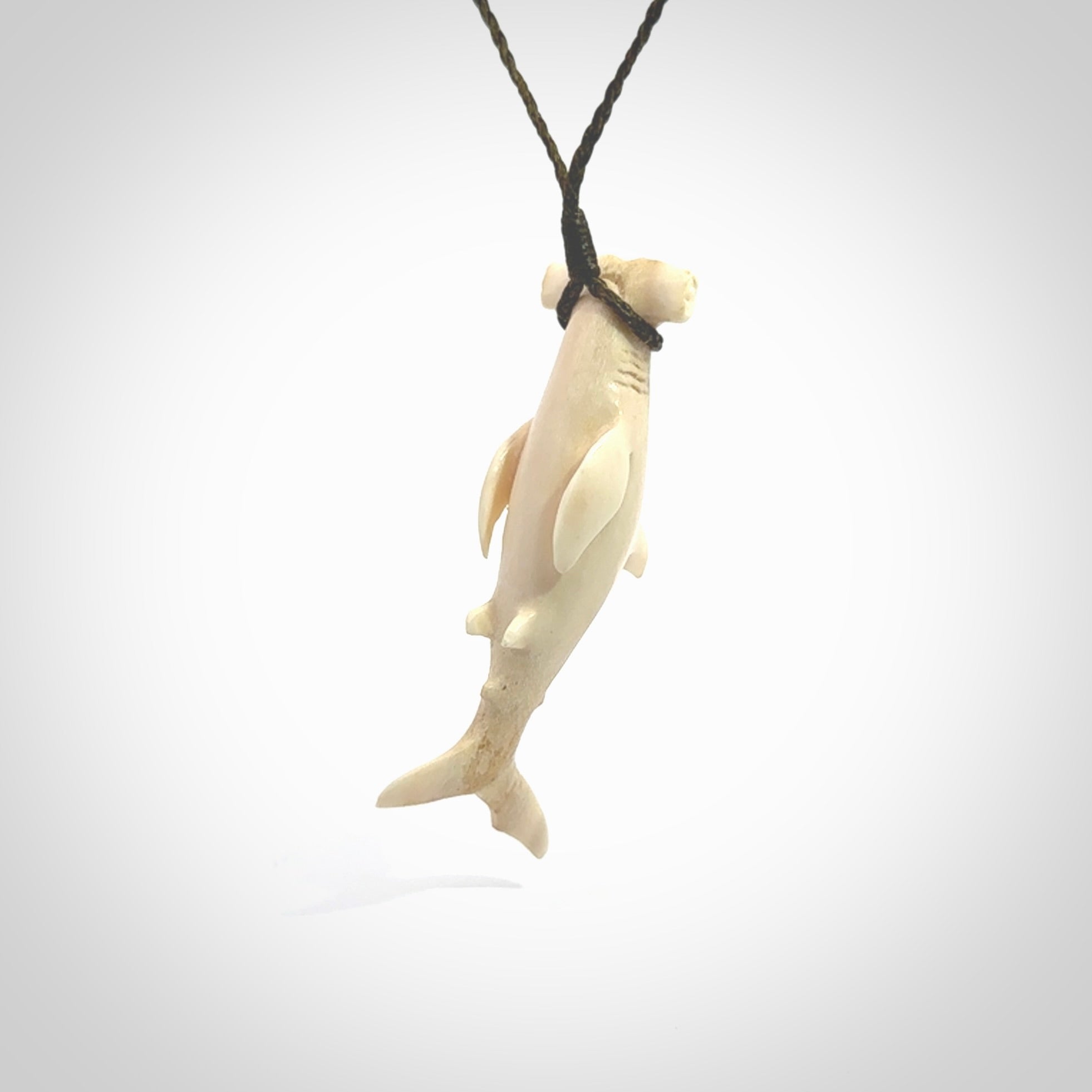 Winghead or hammerhead shark pendant. Handcarved from deer antler by NZ Pacific. Handcarved bone jewellery for sale online. Provided with adjustable olive cord.