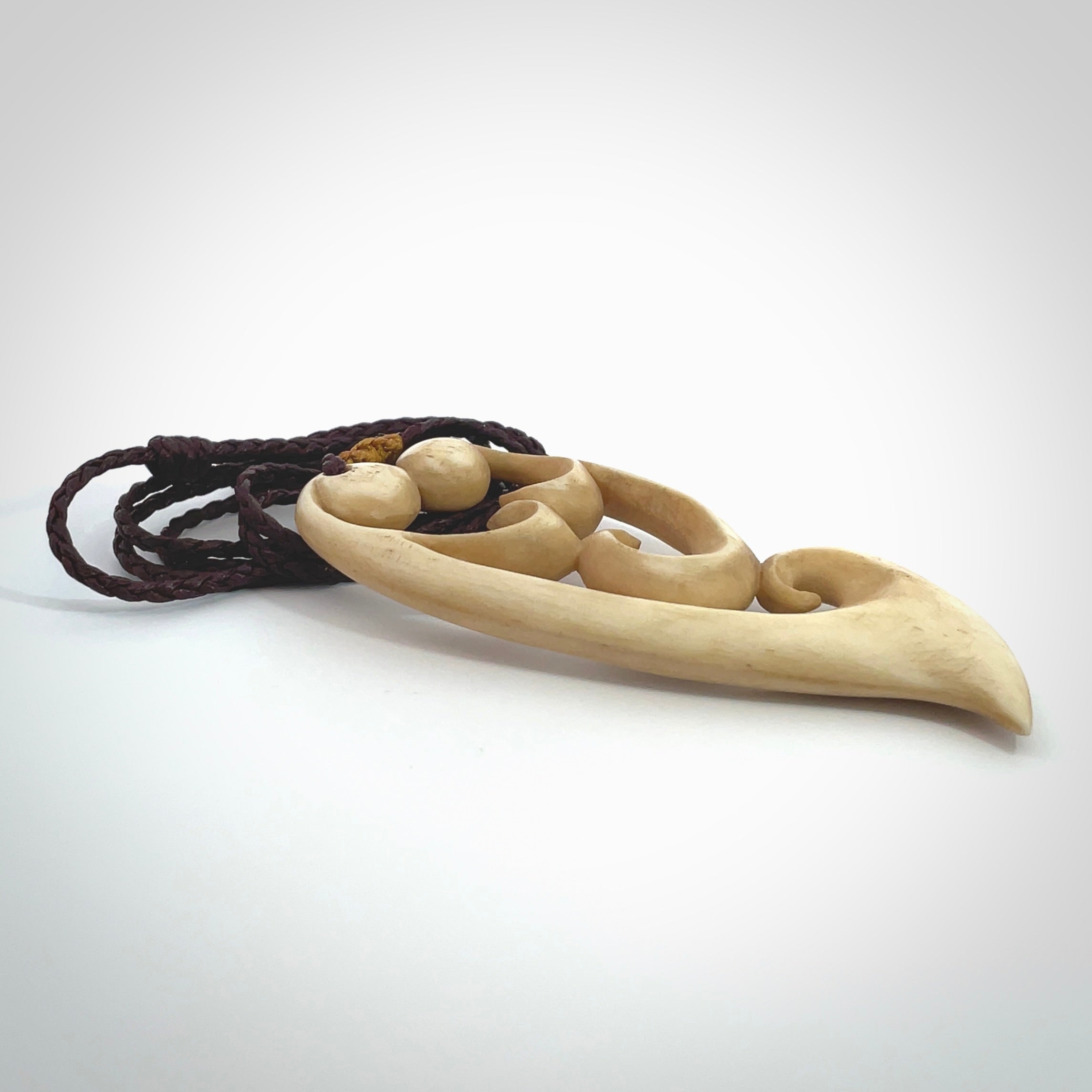 A hand carved masterpiece. A beautiful, large, contemporary pendant carved from bone by Yuri Terenyi for NZ Pacific. This is a true piece of wearable art which is collectible. A one-off pendant representing a mother and child. Provided with an adjustable chocolate brown cord and packaged in a woven kete pouch.