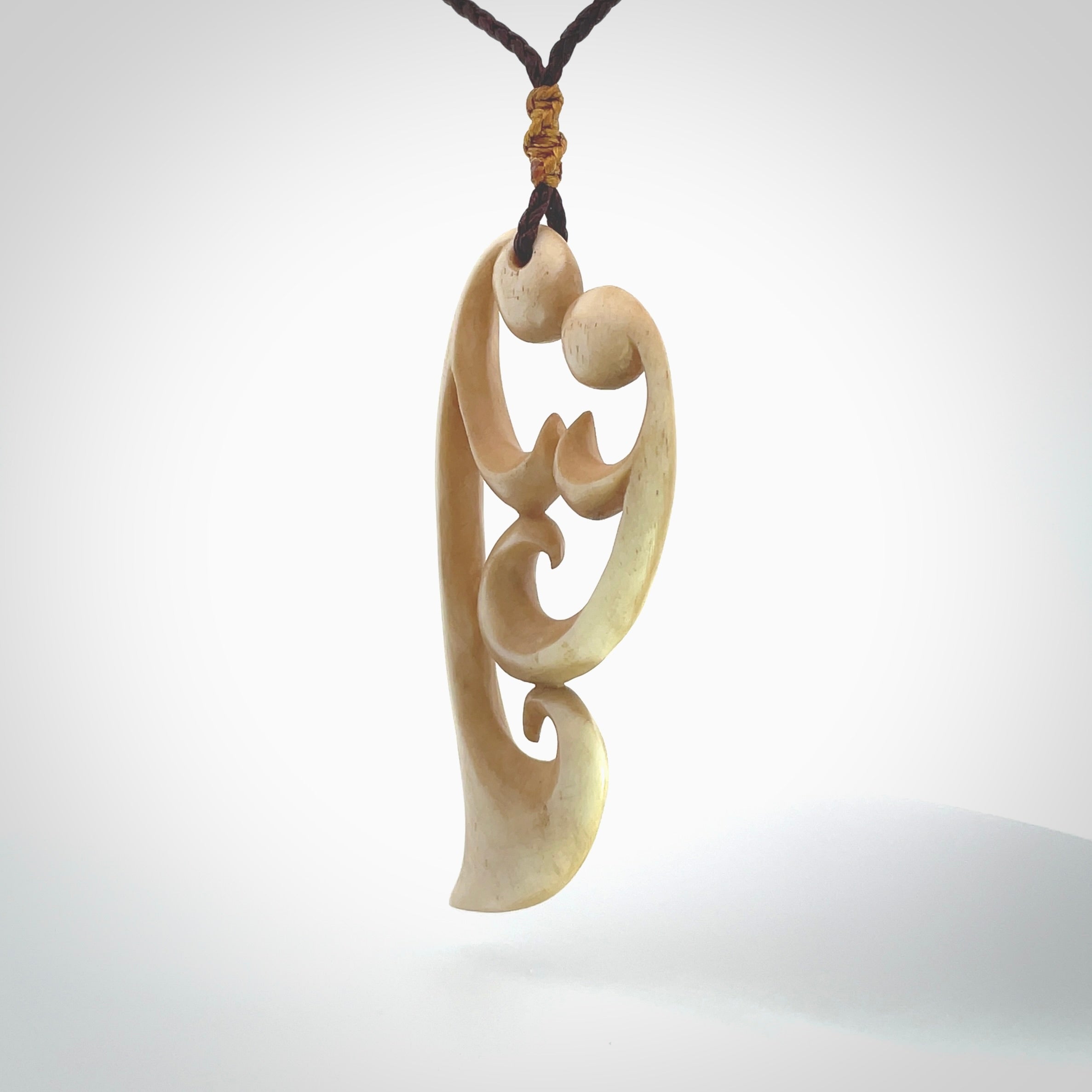 A hand carved masterpiece. A beautiful, large, contemporary pendant carved from bone by Yuri Terenyi for NZ Pacific. This is a true piece of wearable art which is collectible. A one-off pendant representing a mother and child. Provided with an adjustable chocolate brown cord and packaged in a woven kete pouch.