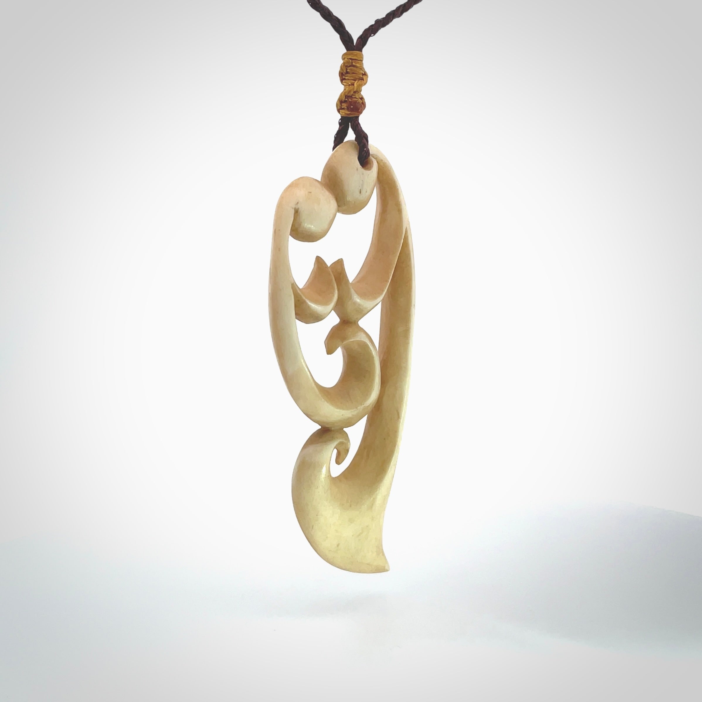 A hand carved masterpiece. A beautiful, large, contemporary pendant carved from bone by Yuri Terenyi for NZ Pacific. This is a true piece of wearable art which is collectible. A one-off pendant representing a mother and child. Provided with an adjustable chocolate brown cord and packaged in a woven kete pouch.