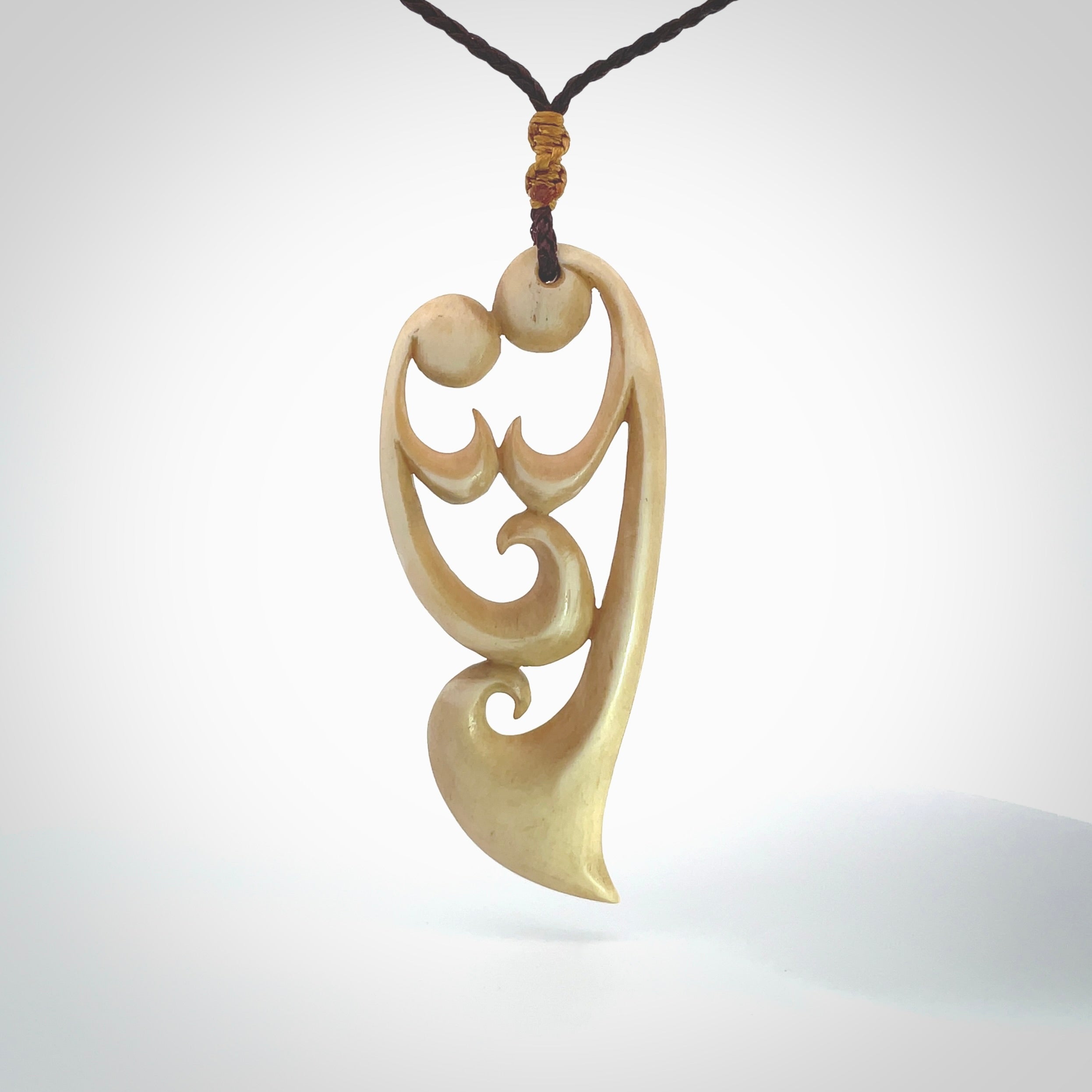 A hand carved masterpiece. A beautiful, large, contemporary pendant carved from bone by Yuri Terenyi for NZ Pacific. This is a true piece of wearable art which is collectible. A one-off pendant representing a mother and child. Provided with an adjustable chocolate brown cord and packaged in a woven kete pouch.