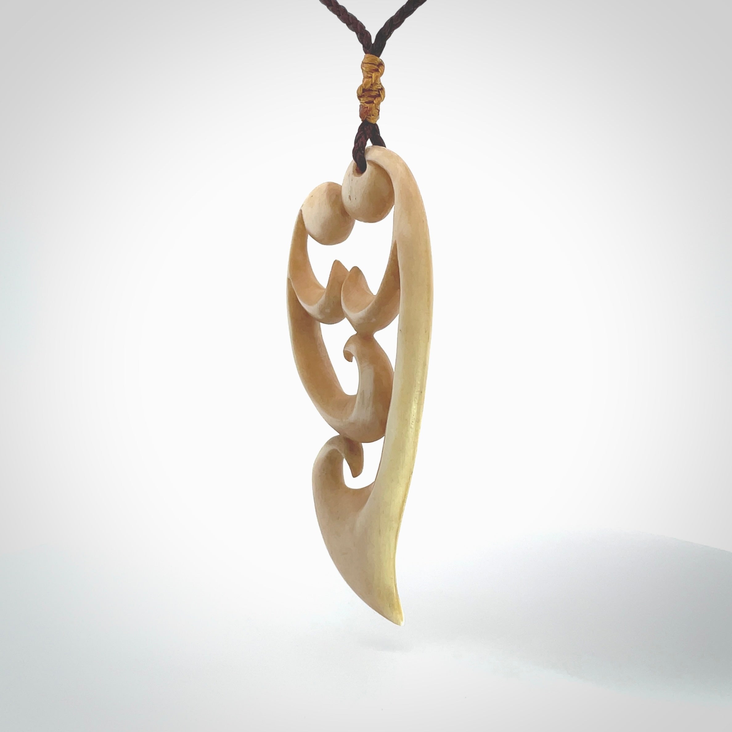 A hand carved masterpiece. A beautiful, large, contemporary pendant carved from bone by Yuri Terenyi for NZ Pacific. This is a true piece of wearable art which is collectible. A one-off pendant representing a mother and child. Provided with an adjustable chocolate brown cord and packaged in a woven kete pouch.