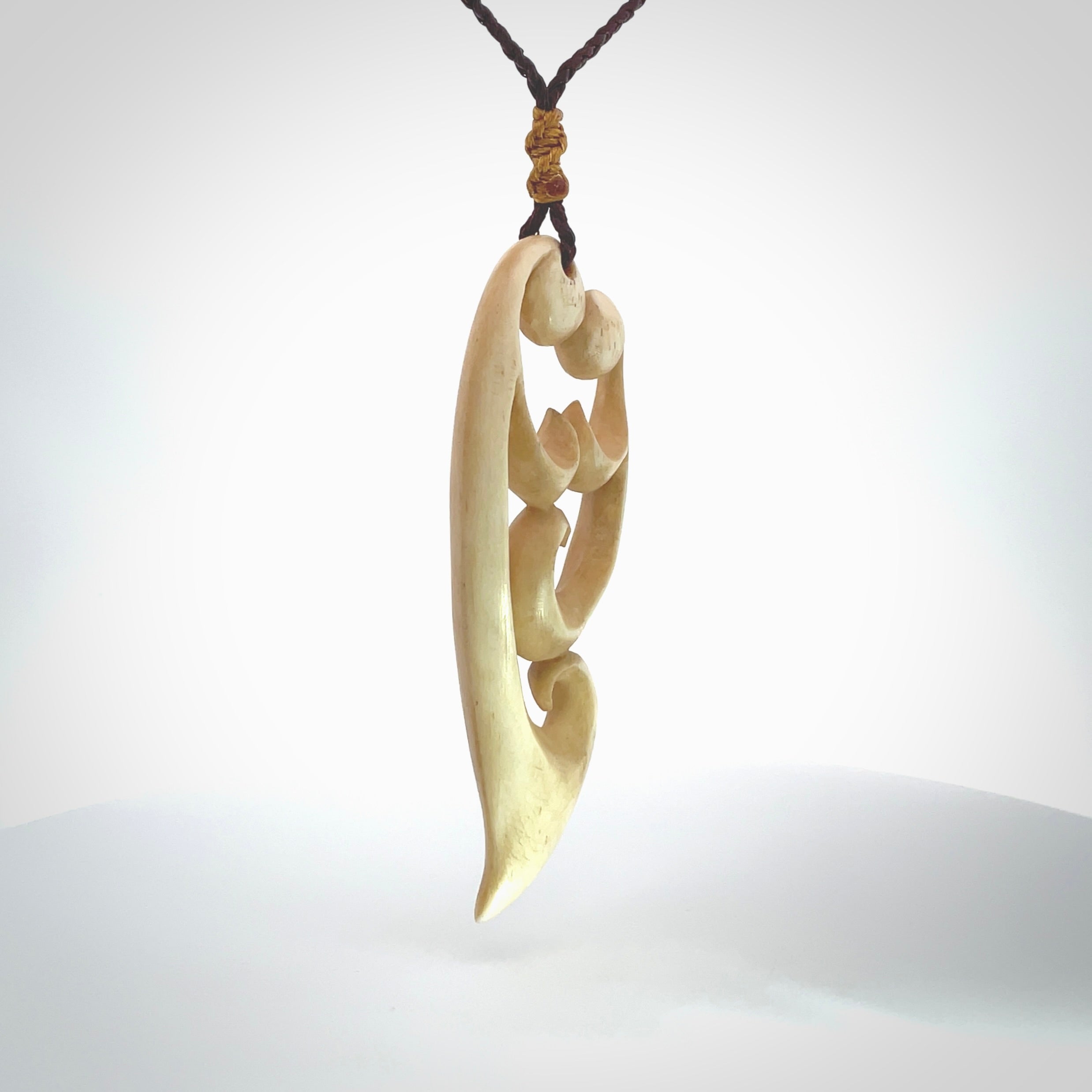 A hand carved masterpiece. A beautiful, large, contemporary pendant carved from bone by Yuri Terenyi for NZ Pacific. This is a true piece of wearable art which is collectible. A one-off pendant representing a mother and child. Provided with an adjustable chocolate brown cord and packaged in a woven kete pouch.