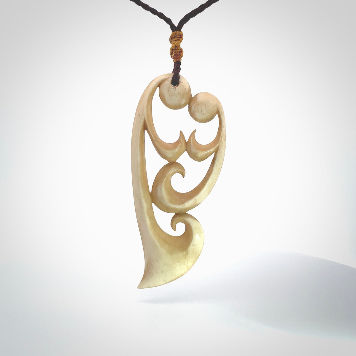 A hand carved masterpiece. A beautiful, large, contemporary pendant carved from bone by Yuri Terenyi for NZ Pacific. This is a true piece of wearable art which is collectible. A one-off pendant representing a mother and child. Provided with an adjustable chocolate brown cord and packaged in a woven kete pouch.