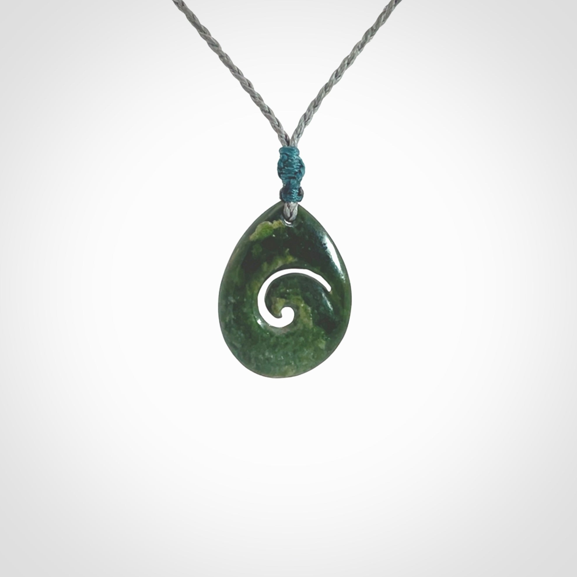 Hand carved New Zealand jade koru drop pendant. Made by NZ Pacific.Hand carved New Zealand jade koru drop pendant. Made by NZ Pacific.