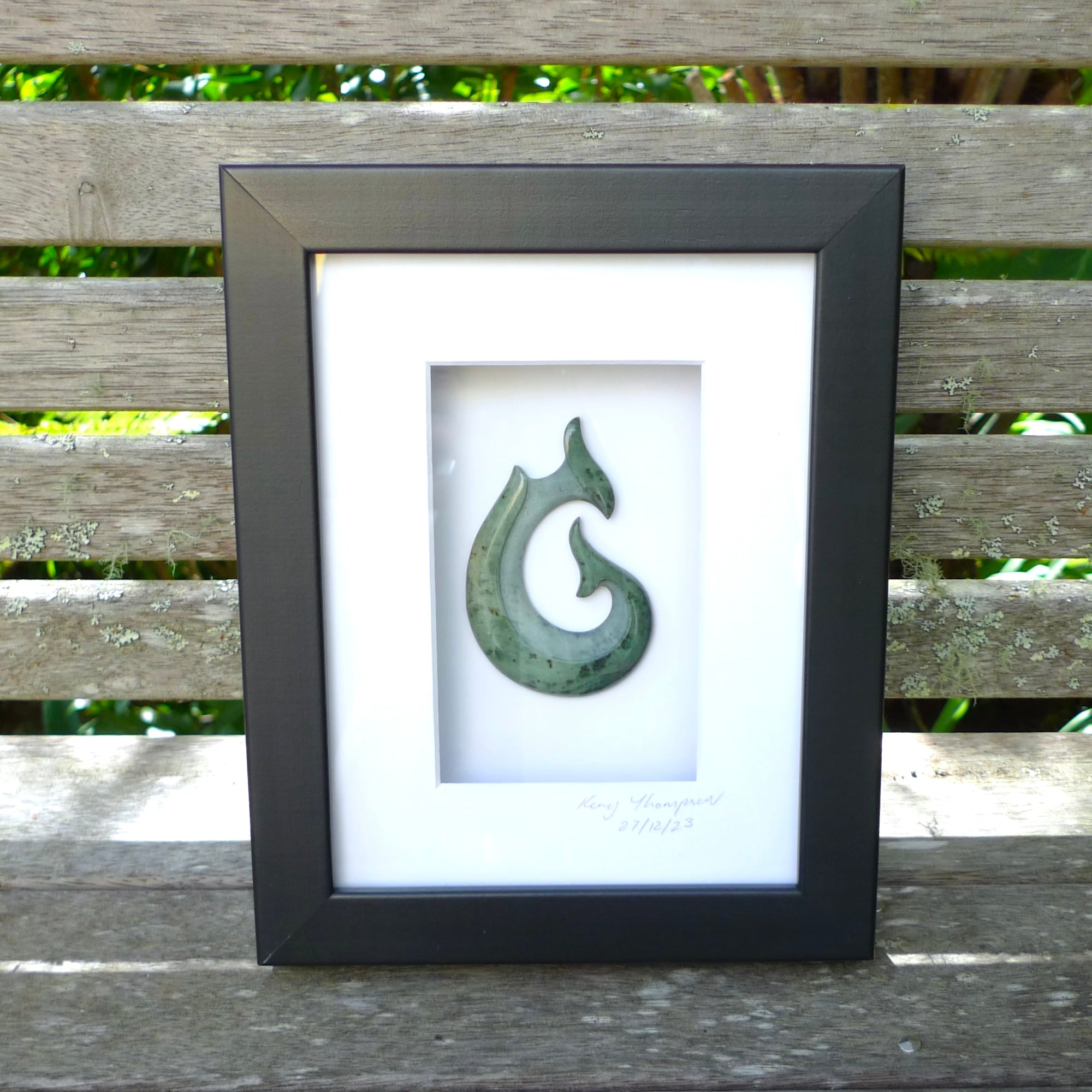 A hand carved large New Zealand Jade Hook, Matau, necklace that has been framed and signed by artist Kerry Thompson. A large sized hand made hook necklace by New Zealand artist Kerry Thompson. One off framed work of art to wear. Delivered with Express Courier.