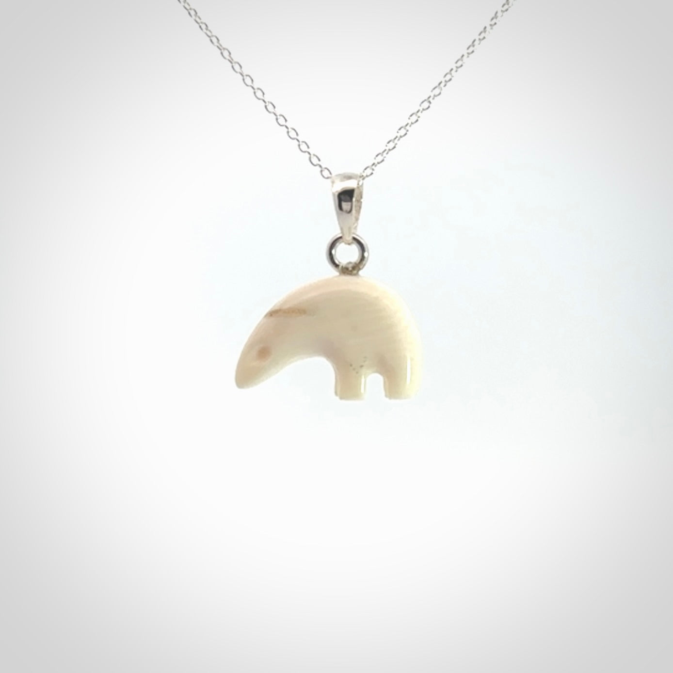 Hand made woolly mammoth tusk sea bear necklace with Sterling Silver. Mammoth tusk polar bear pendant with Sterling silver surround and chain. Made by NZ Pacific and sale online only.