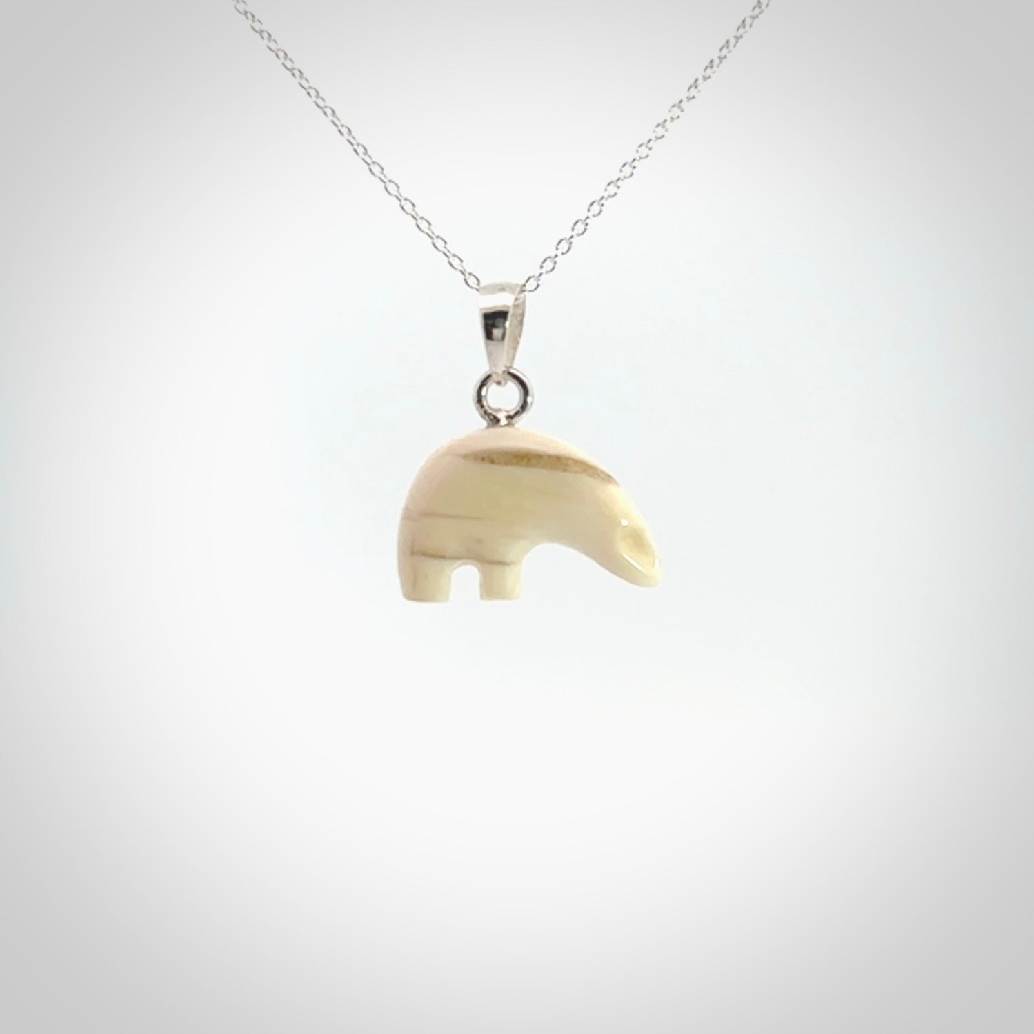 Hand made woolly mammoth tusk sea bear necklace with Sterling Silver. Mammoth tusk polar bear pendant with Sterling silver surround and chain. Made by NZ Pacific and sale online only.