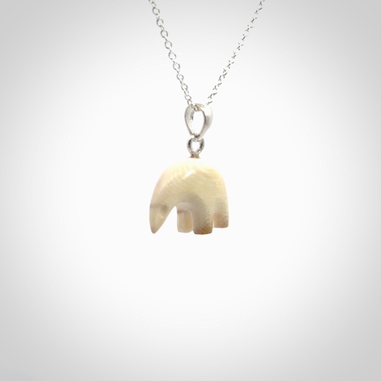 Hand made woolly mammoth tusk sea bear necklace with Sterling Silver. Mammoth tusk polar bear pendant with Sterling silver surround and chain. Made by NZ Pacific and sale online only.