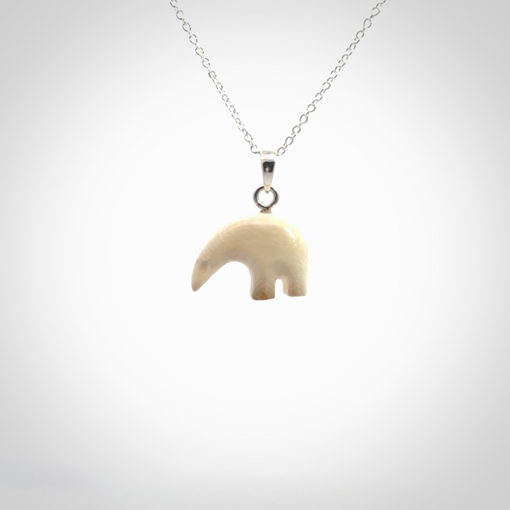 Hand made woolly mammoth tusk sea bear necklace with Sterling Silver. Mammoth tusk polar bear pendant with Sterling silver surround and chain. Made by NZ Pacific and sale online only.