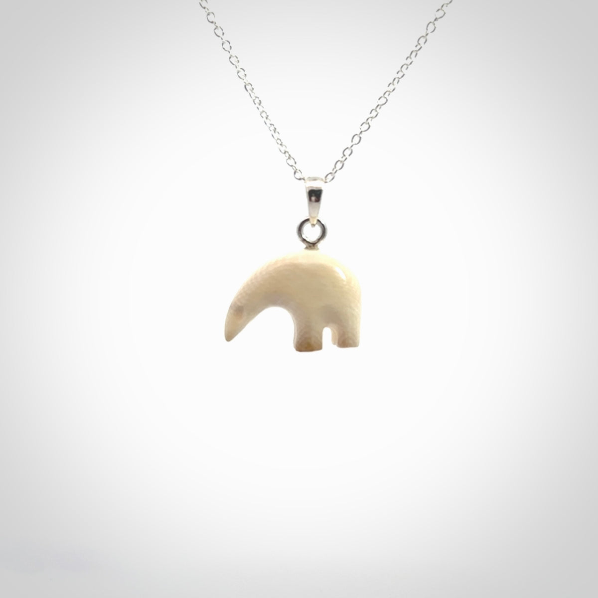 Hand made woolly mammoth tusk sea bear necklace with Sterling Silver. Mammoth tusk polar bear pendant with Sterling silver surround and chain. Made by NZ Pacific and sale online only.