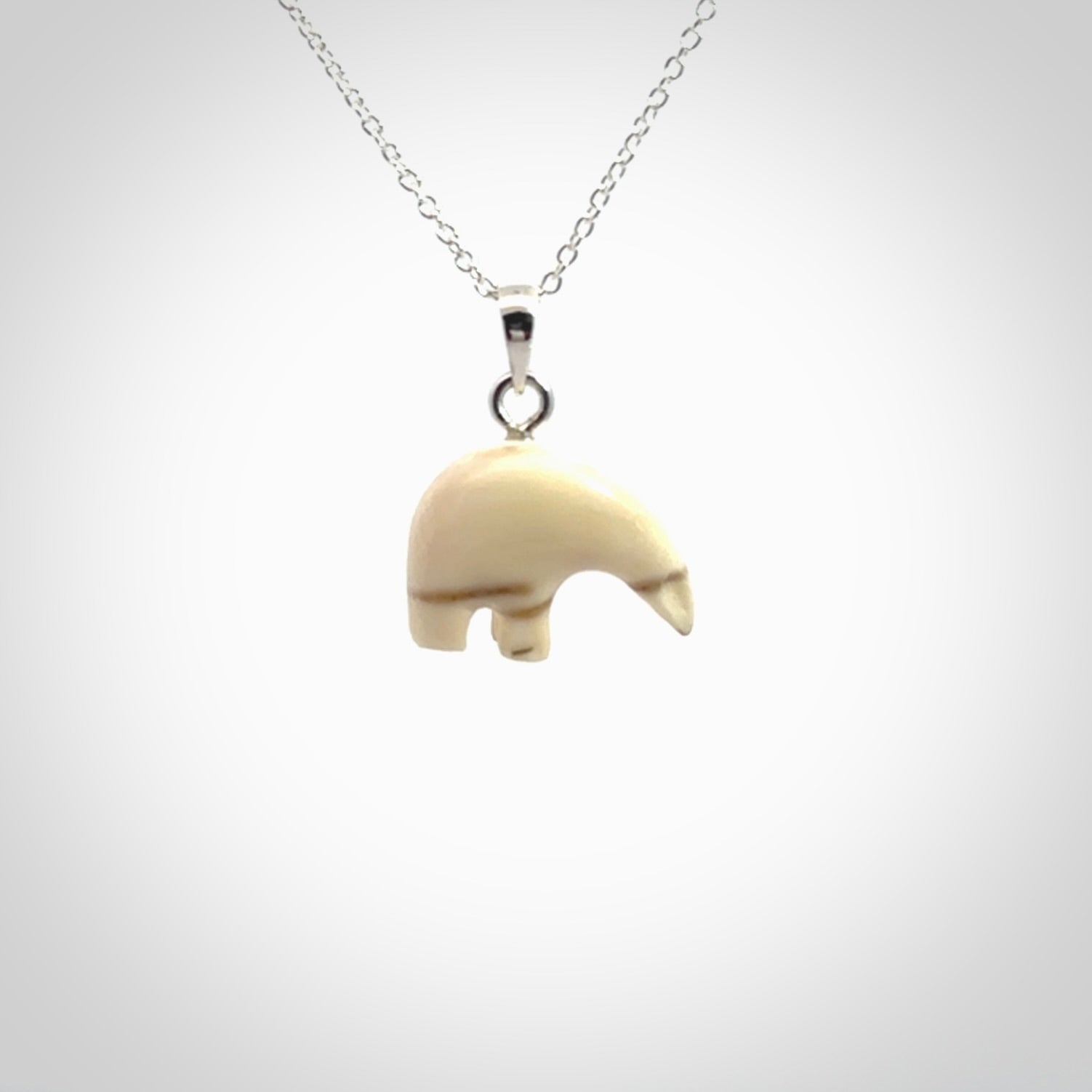 Hand made woolly mammoth tusk sea bear necklace with Sterling Silver. Mammoth tusk polar bear pendant with Sterling silver surround and chain. Made by NZ Pacific and sale online only.