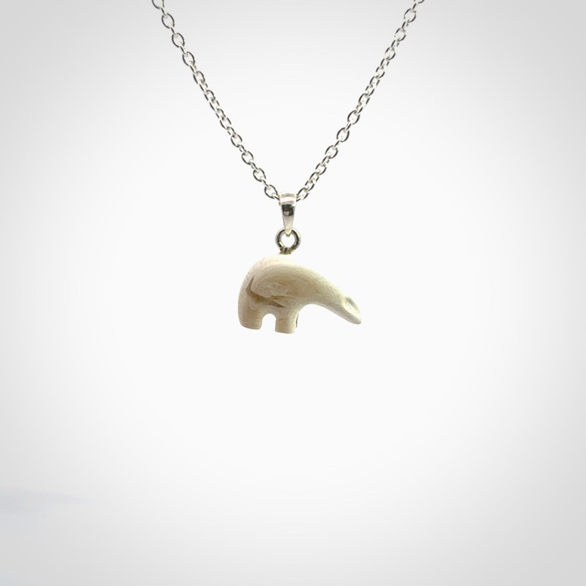 Hand made woolly mammoth tusk sea bear necklace with Sterling Silver. Mammoth tusk polar bear pendant with Sterling silver surround and chain. Made by NZ Pacific and sale online only.