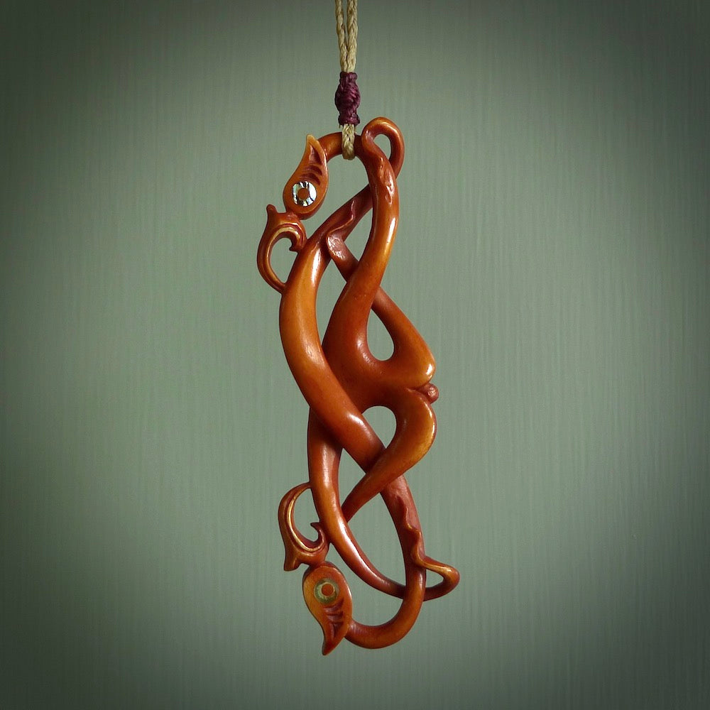 This necklace is carved from cow bone and stained with a homemade tea dye. It is a unique piece of wearable art that is sure to catch the eye. The shape is a complex twist form and has been beautifully hand carved by bone carver Yuri Terenyi.