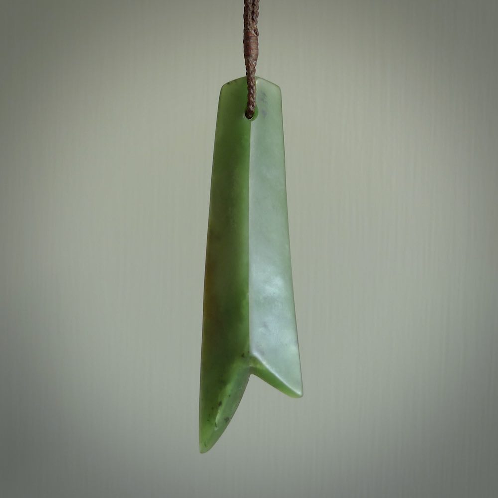 This piece is a fine, delicate pendant. It was carved for us by Ric Moor from a lovely semi-translucent green piece of New Zealand Marsden jade. It is suspended on an dark brown  four plaited braided cord that is length adjustable.