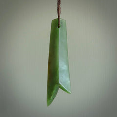 This piece is a fine, delicate pendant. It was carved for us by Ric Moor from a lovely semi-translucent green piece of New Zealand Marsden jade. It is suspended on an dark brown  four plaited braided cord that is length adjustable.