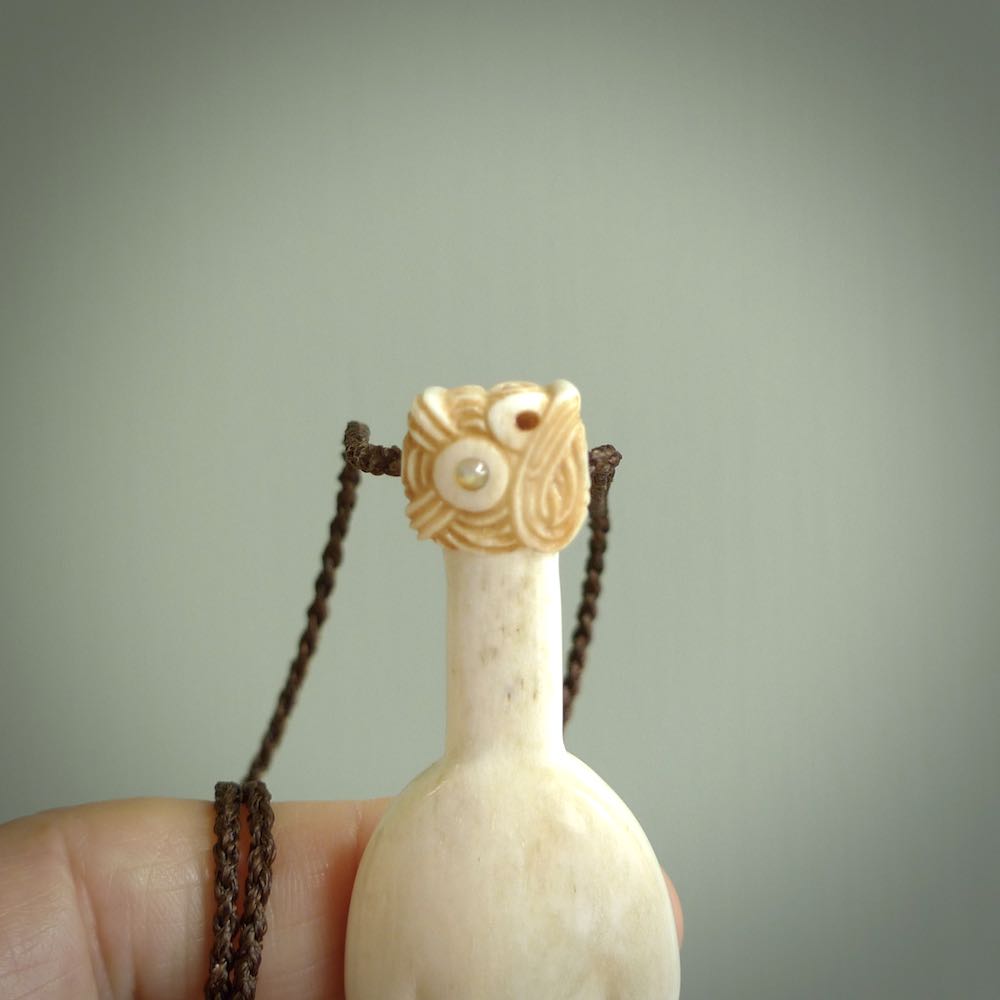 Hand carved engraved bone patu necklace hand made here in New Zealand. One only artistic patu pendant with hand plaited dark brown adjustable cord. Shipped to you with Express Courier. Stand out patu pendant for men and women. Bone patu with Paua shell insert eyes.