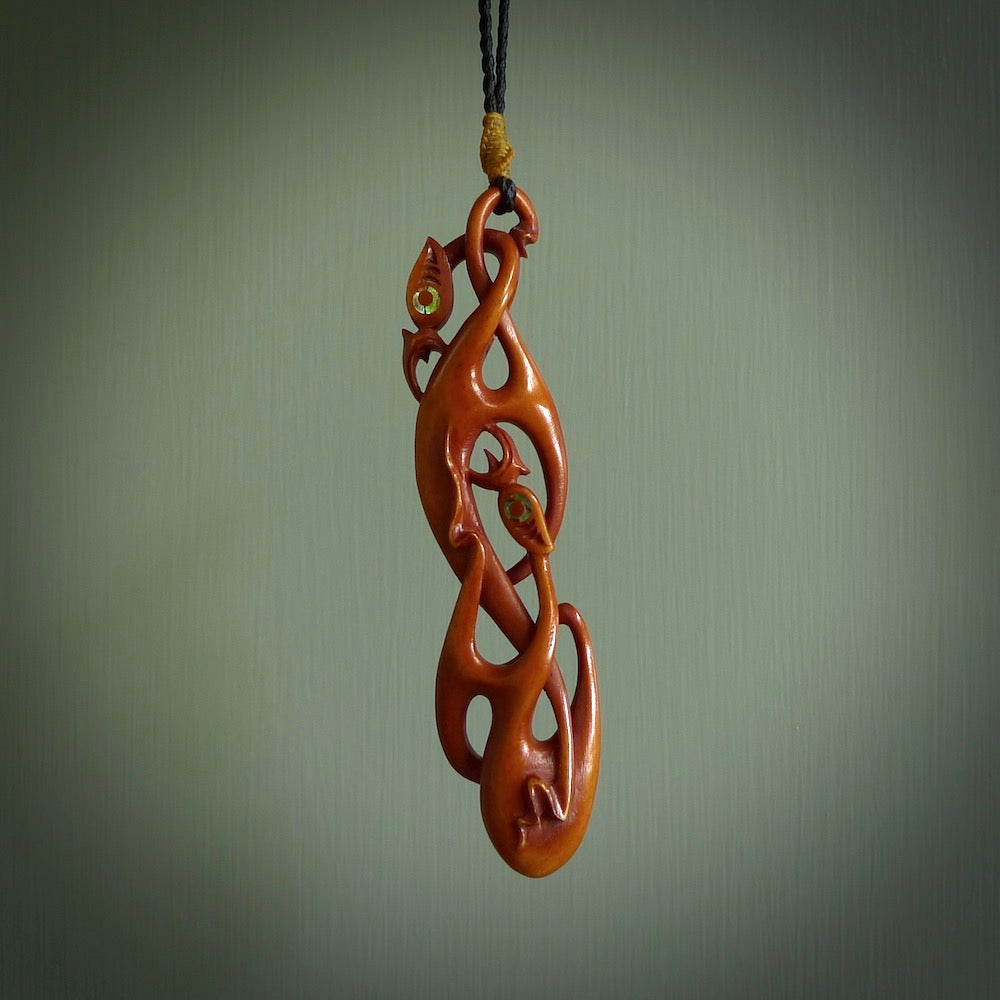 A one off beautiful piece of carved art. Hand carved for us by Yuri Terenyi and is a double manaia pendant. This is a wonderful ethnic bone pendant designed to be worn. It has been stained by a homemade tea dye in a bright gingery brown colour and we have hand plaited an adjustable cord in black with a burnt gold floret popper.