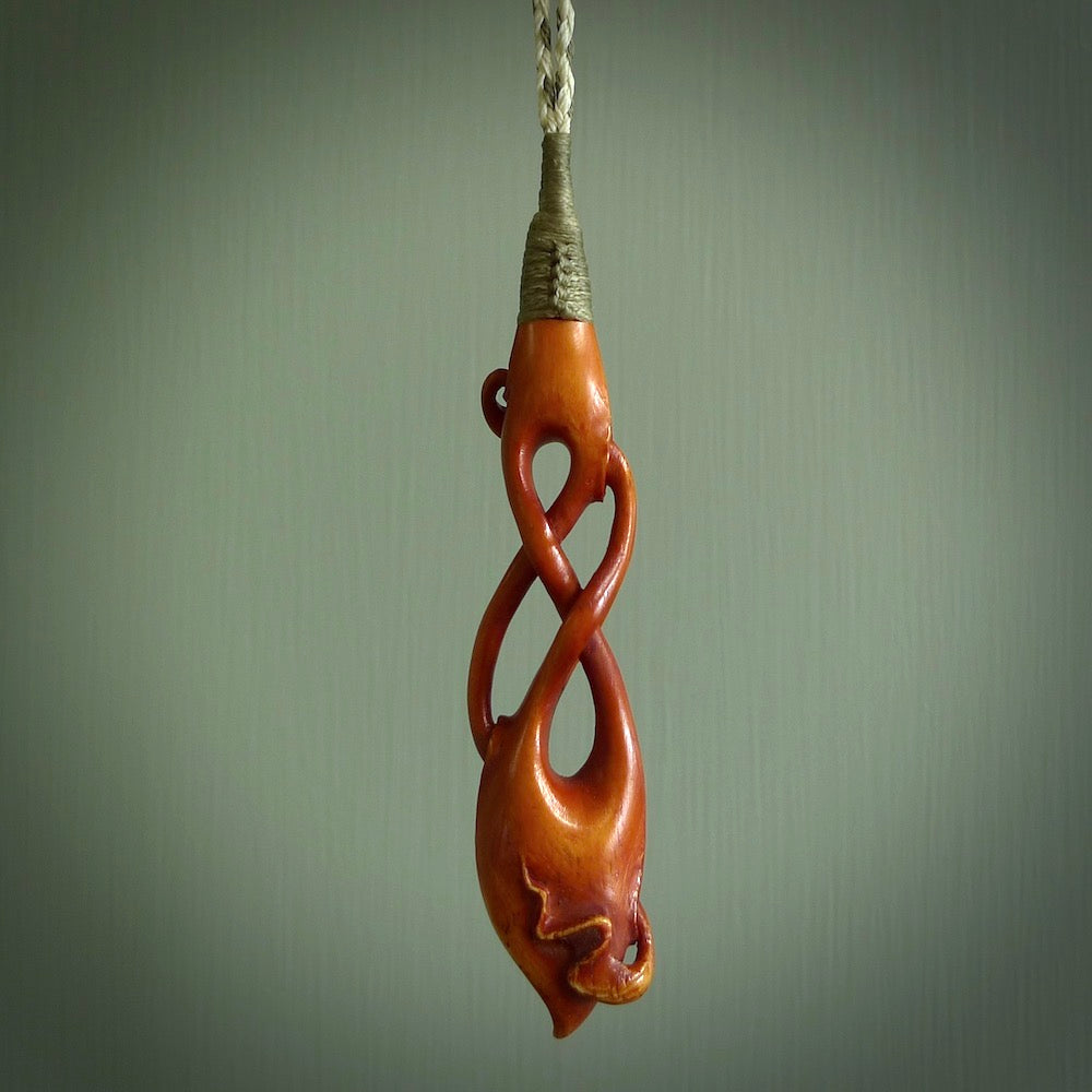 This pendant is carved from cow bone and stained with a homemade tea dye. It is a unique piece of wearable art that is sure to catch the eye. The shape is a complex twist form and has been beautifully hand carved by bone carver Yuri Terenyi.