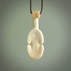 Hand carved engraved bone patu necklace hand made here in New Zealand. One only artistic patu pendant with hand plaited dark brown adjustable cord. Shipped to you with Express Courier. Stand out patu pendant for men and women. Bone patu with Paua shell insert eyes.