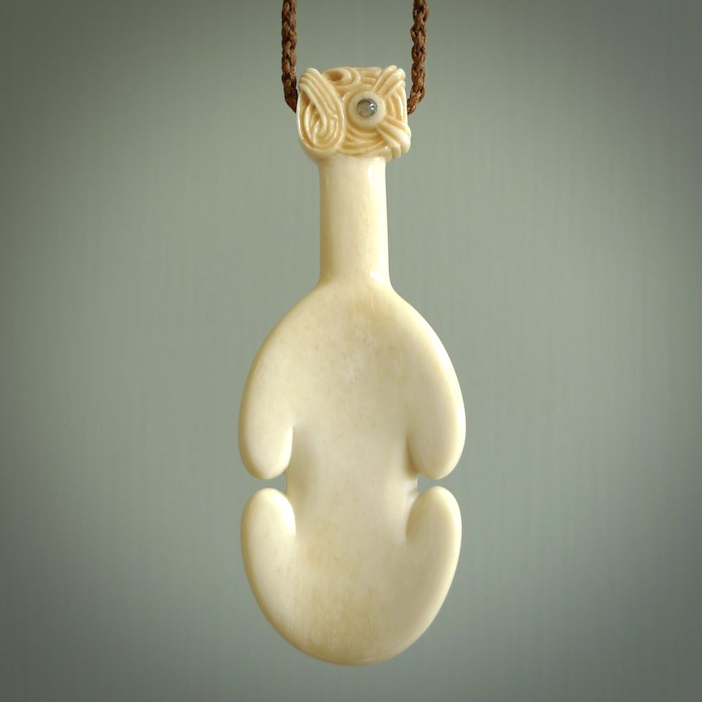 Hand carved engraved bone patu necklace hand made here in New Zealand. One only artistic patu pendant with hand plaited dark brown adjustable cord. Shipped to you with  Express Courier. Stand out patu pendant for men and women. Bone patu with Paua shell insert eyes.